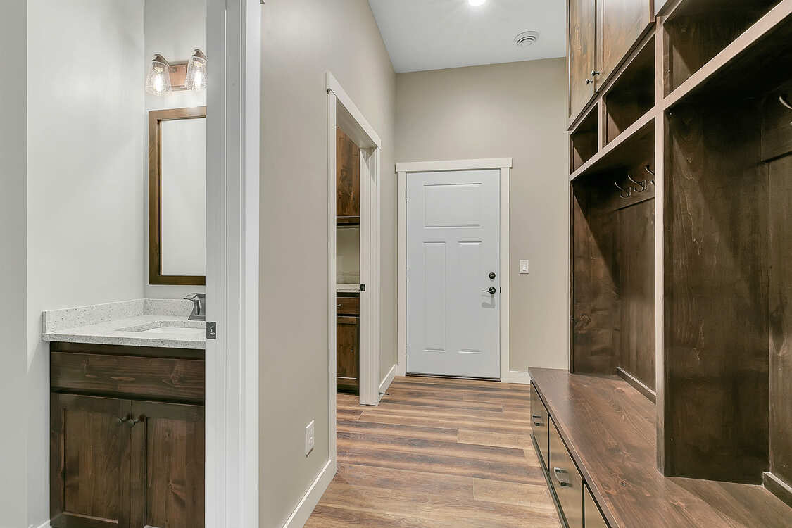 A hallway in a house with a sink and a mirror.