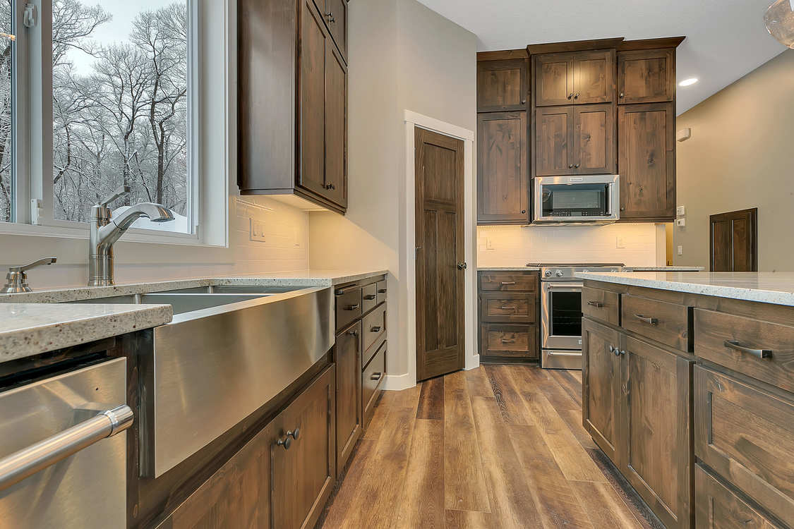 A kitchen with stainless steel appliances and wooden cabinets.