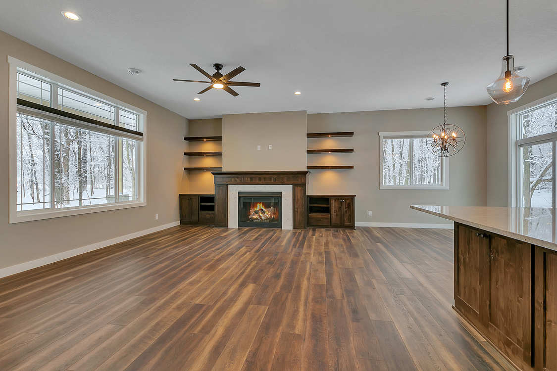An empty living room with hardwood floors and a fireplace.