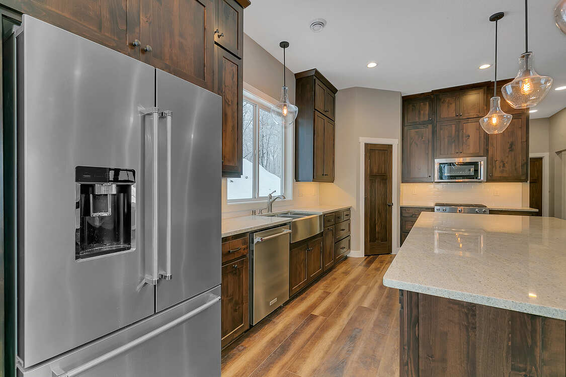 A kitchen with stainless steel appliances and wooden cabinets.