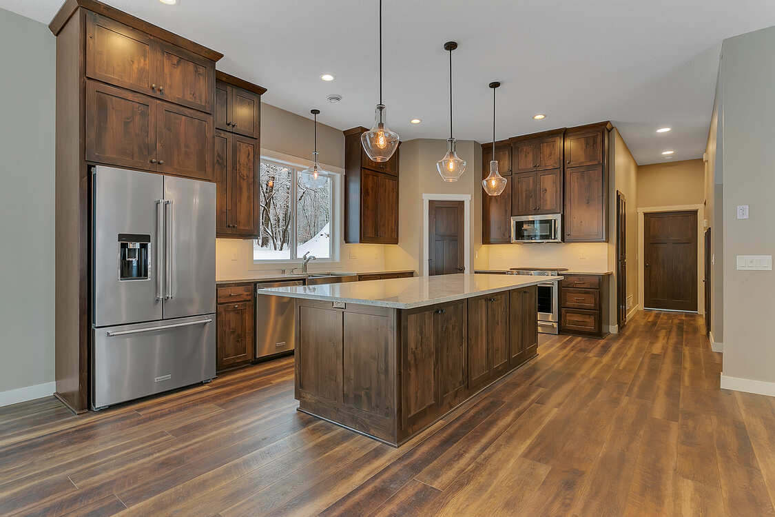 A kitchen with stainless steel appliances , wooden cabinets , and a large island.