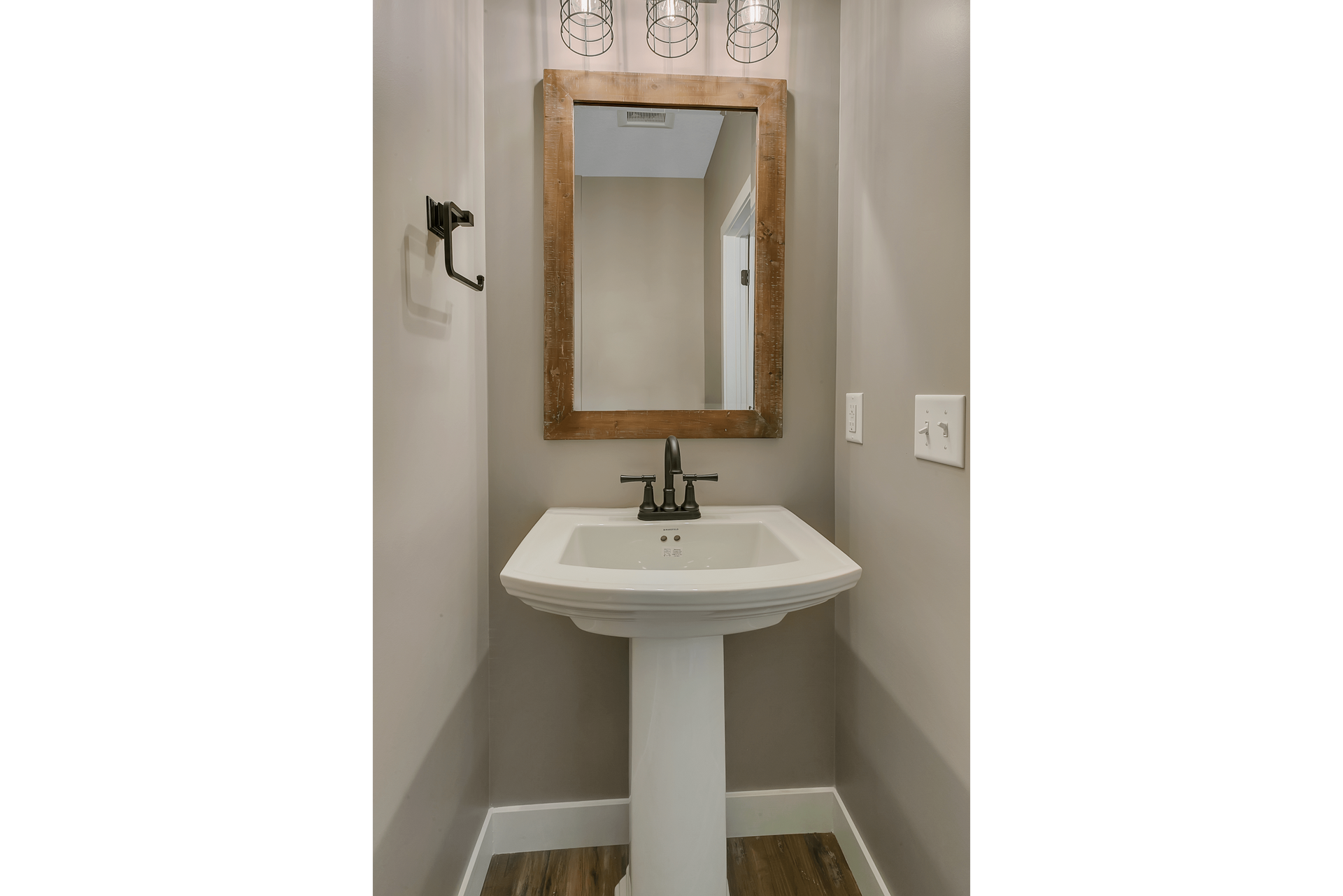 A bathroom with a pedestal sink and a mirror.