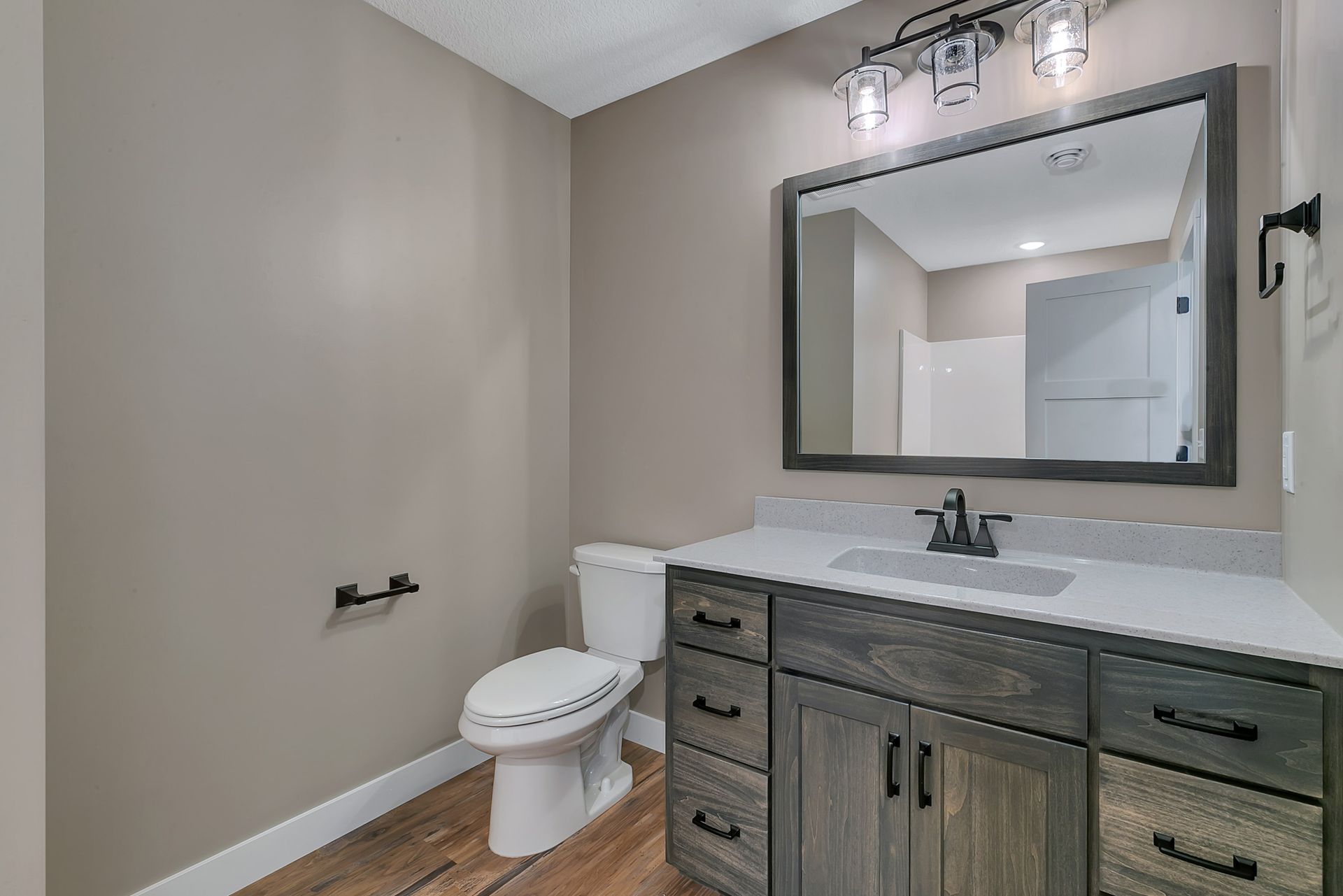 A bathroom with a toilet , sink and mirror.