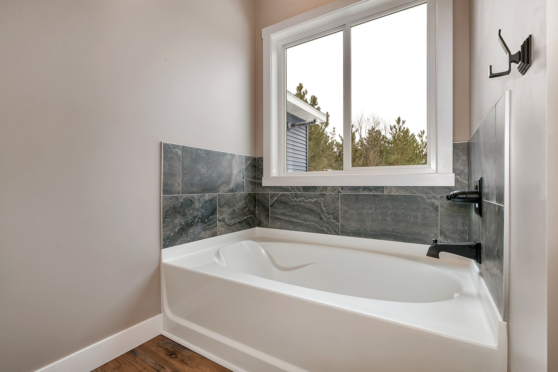 A bathroom with a bathtub and a window.