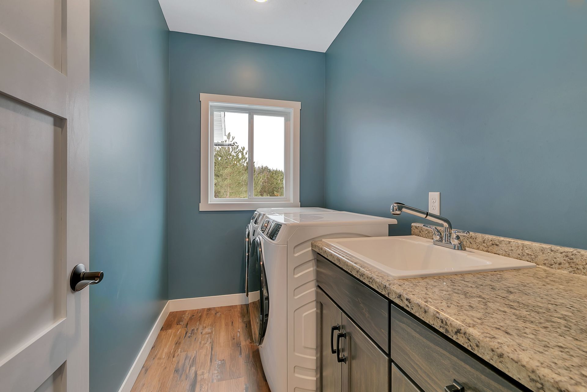 A laundry room with a washer and dryer and a sink.