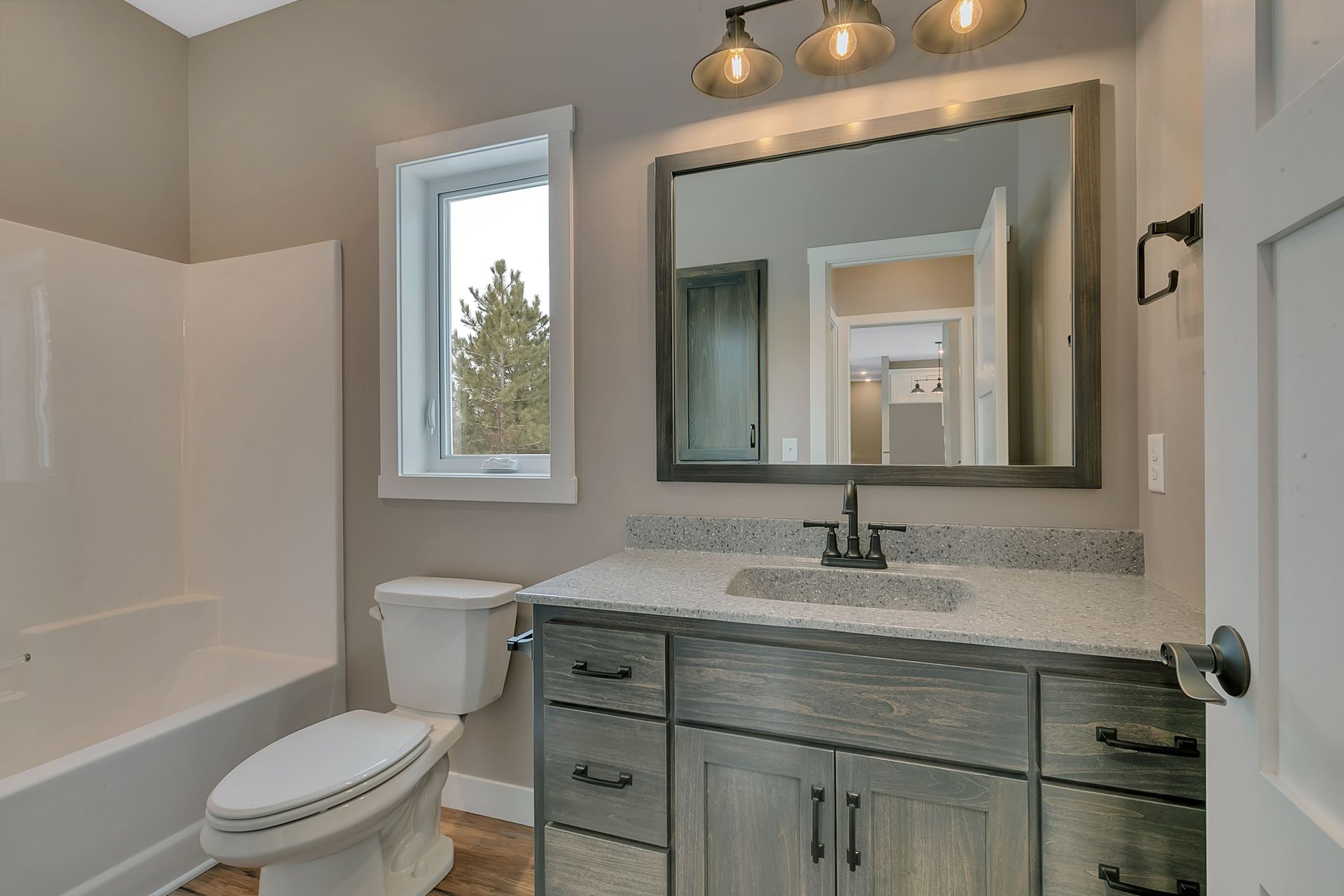 A bathroom with a toilet , sink , and mirror.