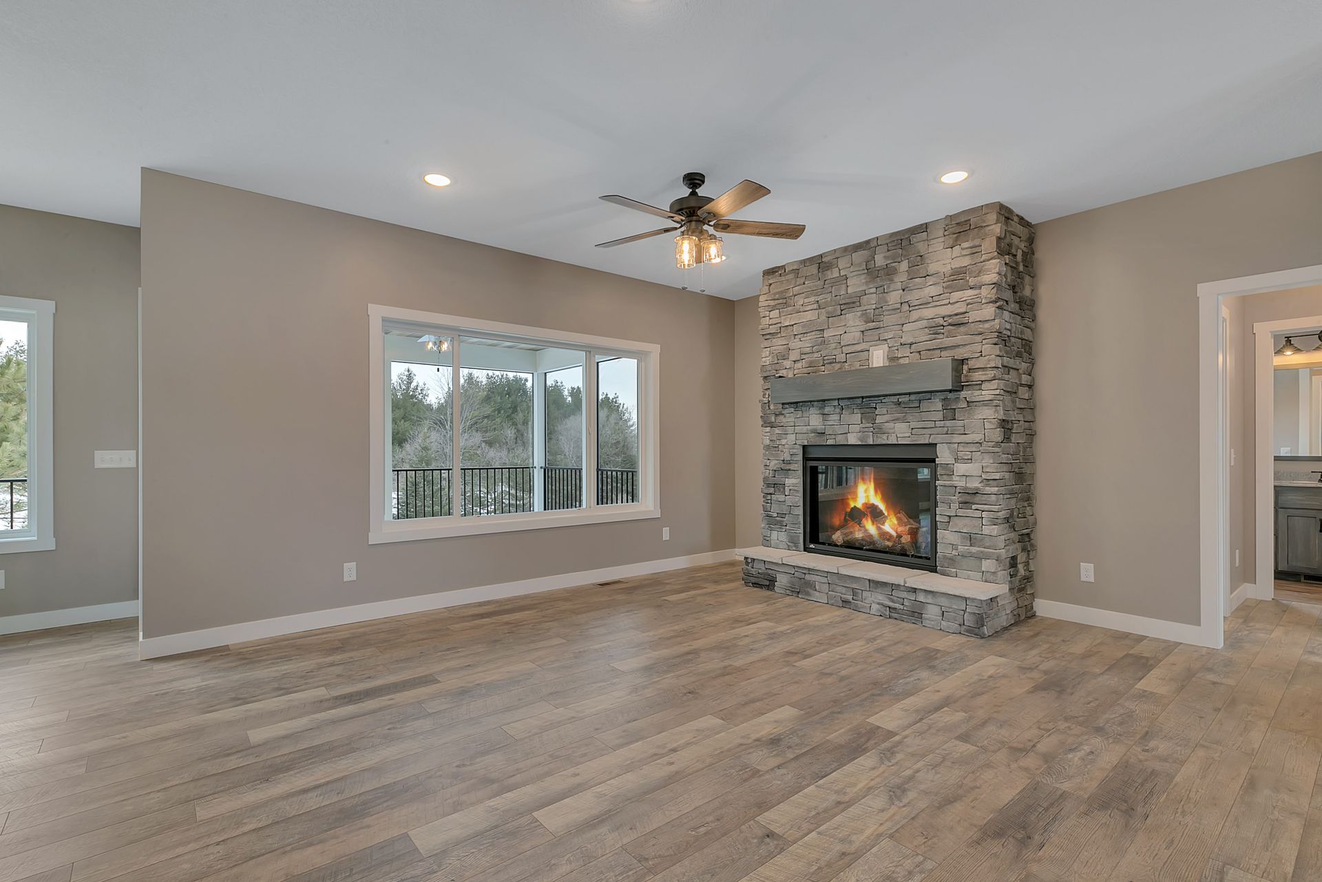 A living room with a fireplace and a ceiling fan.