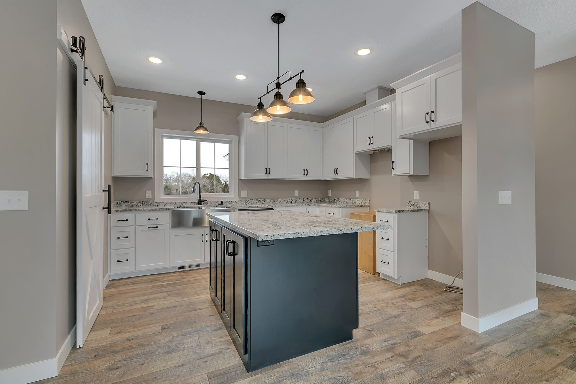 A kitchen with white cabinets and a large island in the middle.