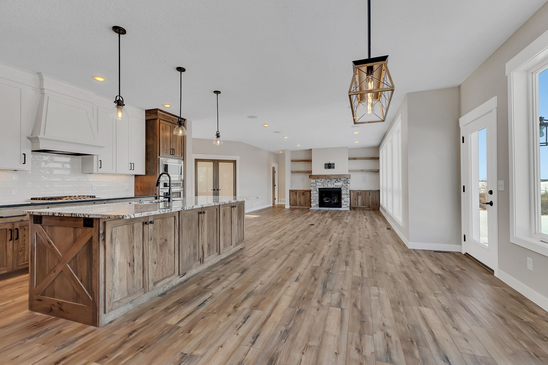 A kitchen and living room in a house with hardwood floors.
