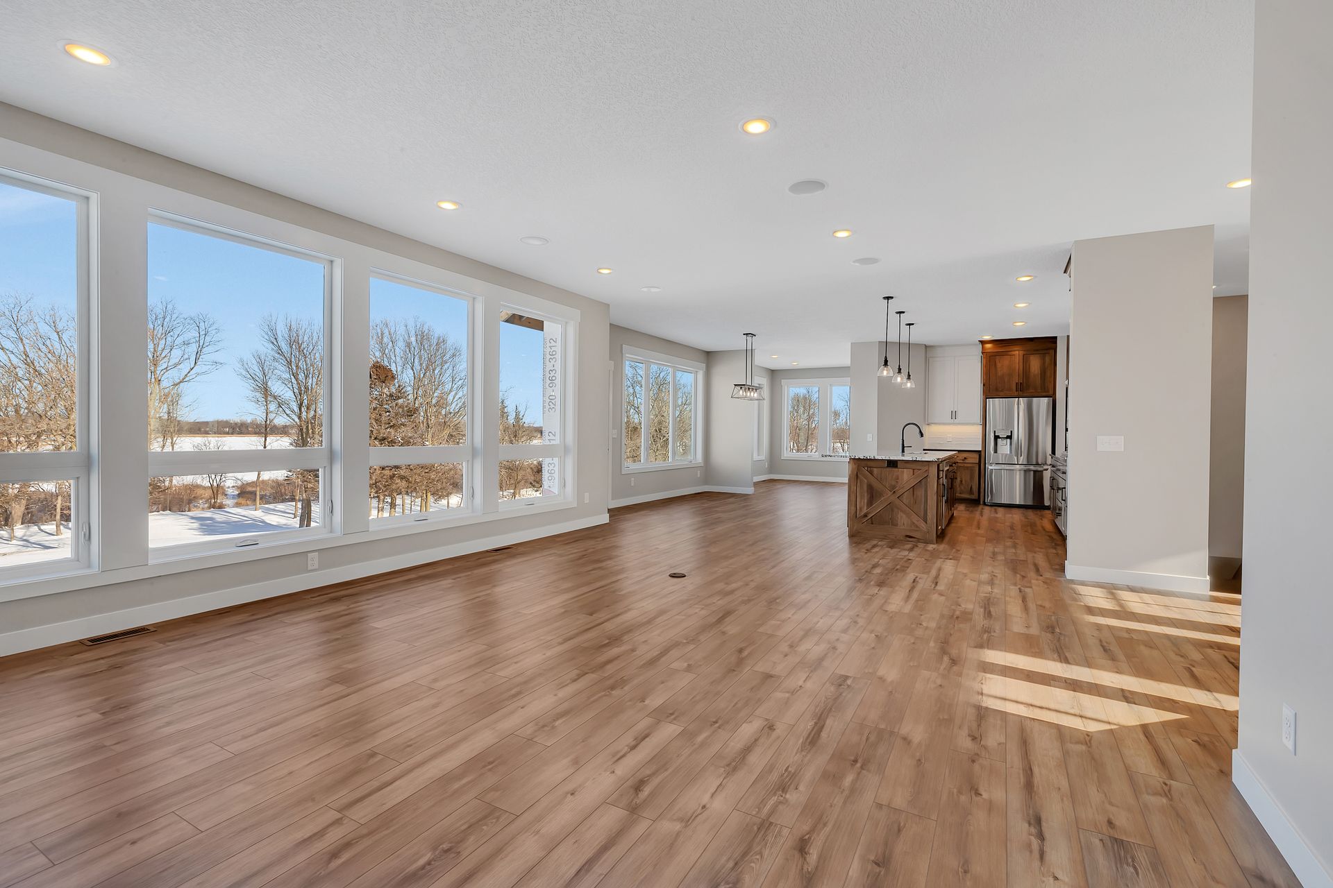 A large empty room with hardwood floors and lots of windows.