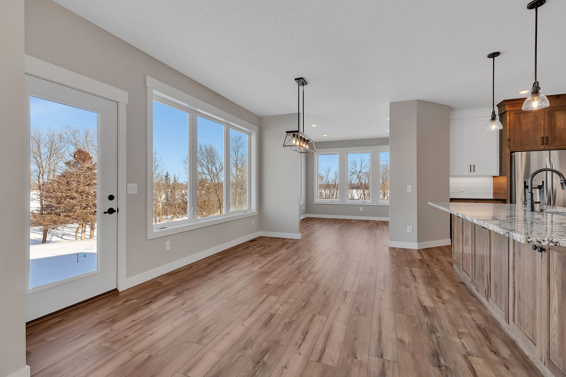 A large empty room with hardwood floors and lots of windows.