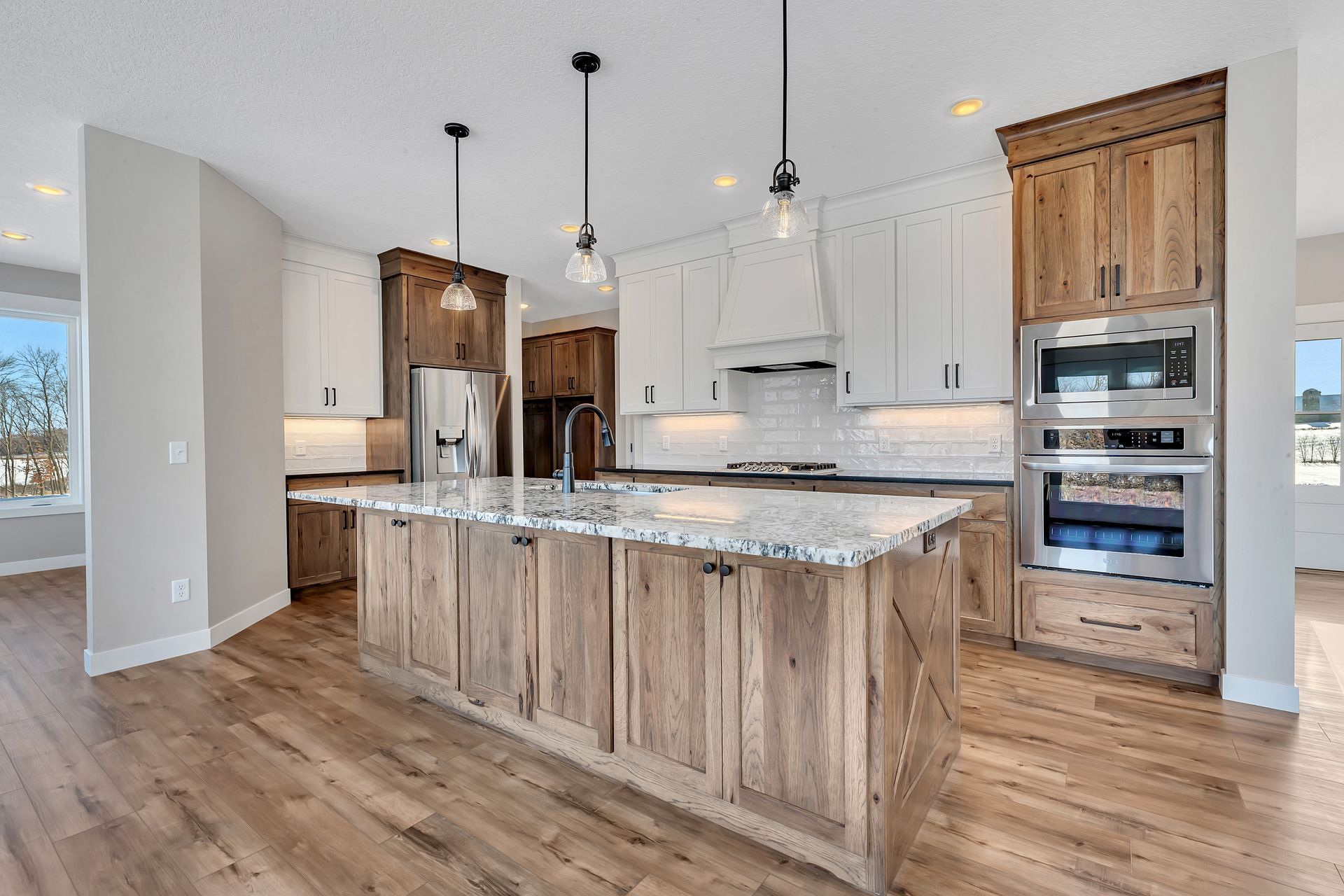 A kitchen with wooden cabinets , granite counter tops , and stainless steel appliances.