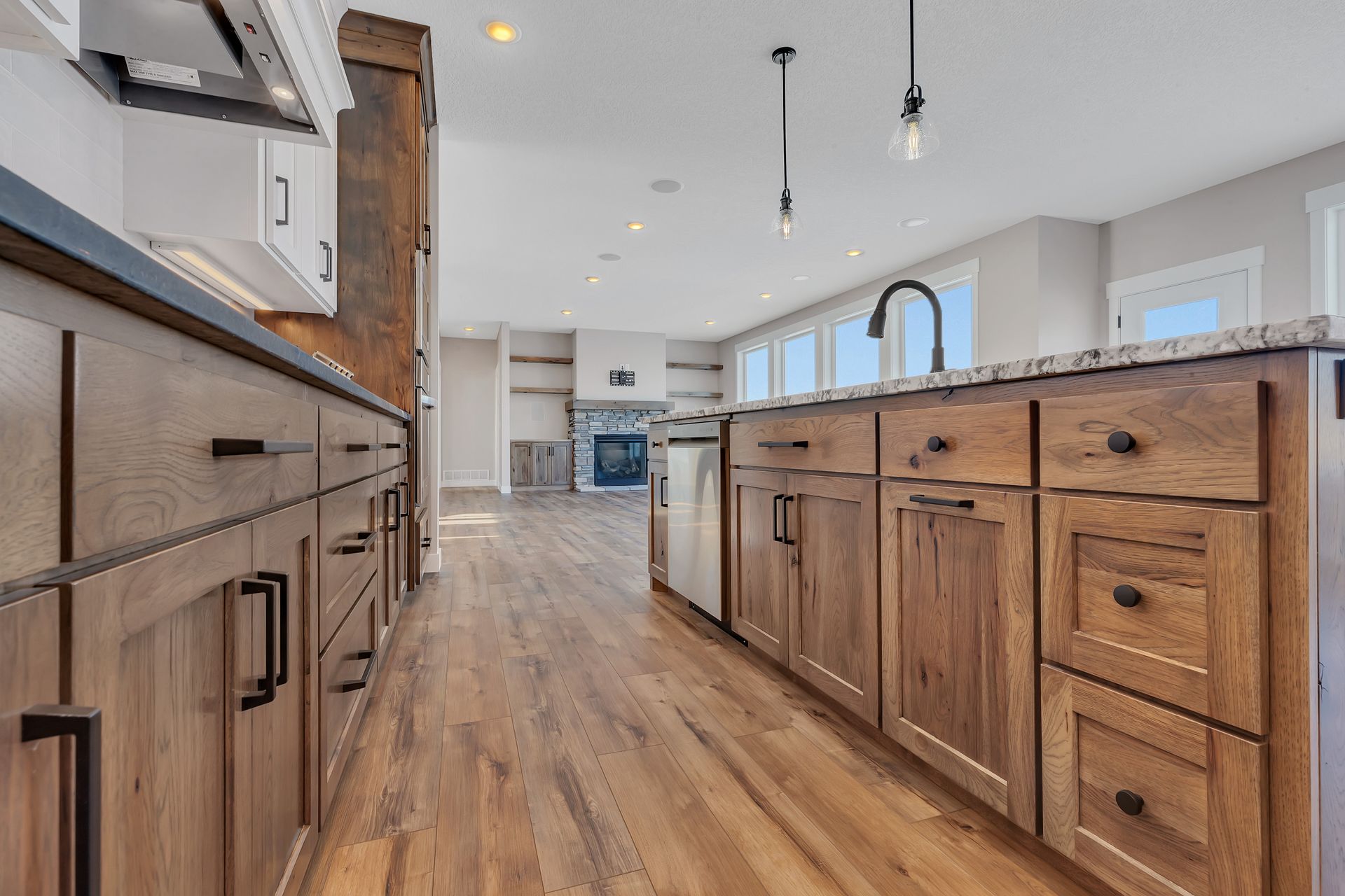A kitchen with wooden cabinets , granite counter tops , and stainless steel appliances.