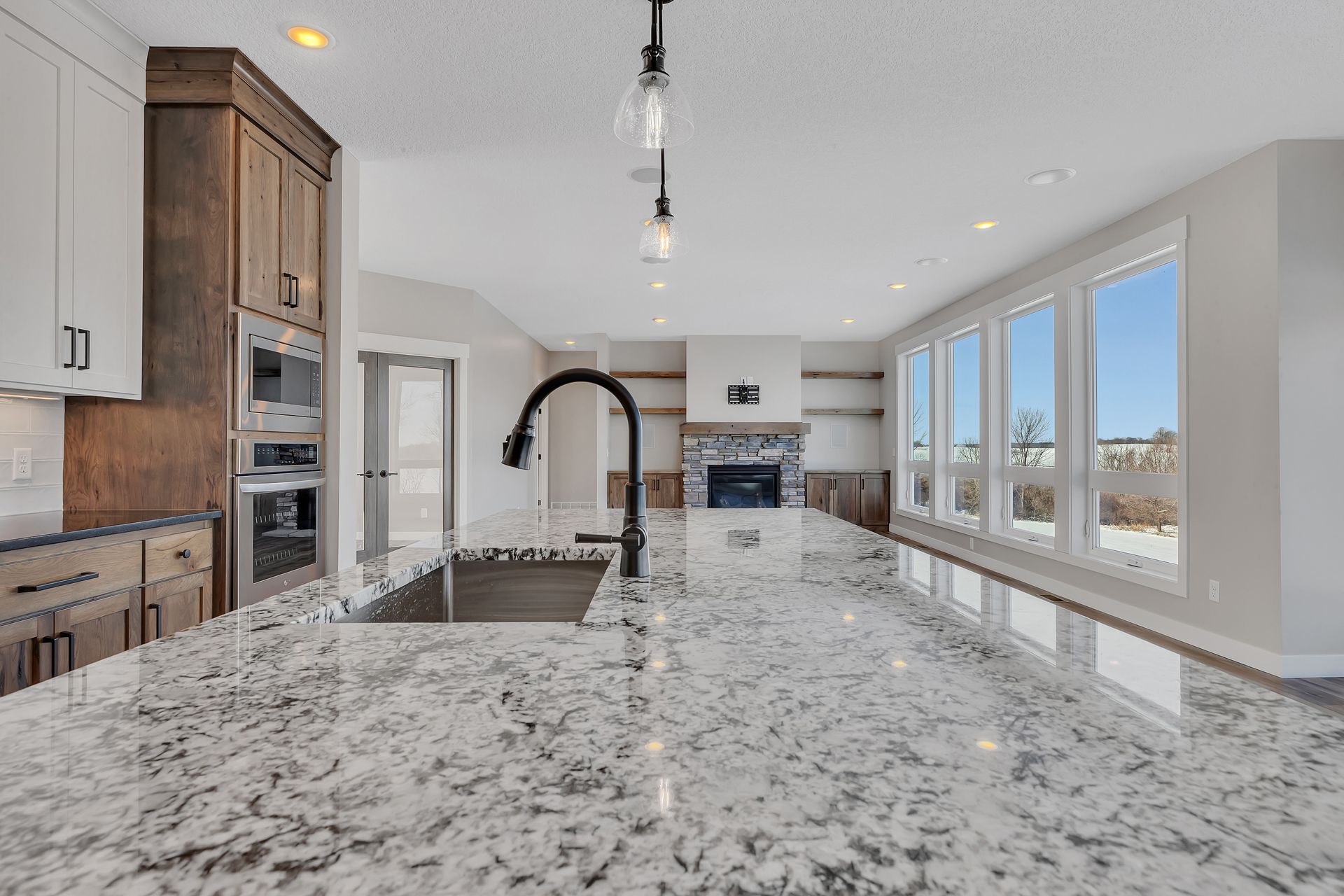 A kitchen with granite counter tops , a sink , and a fireplace.