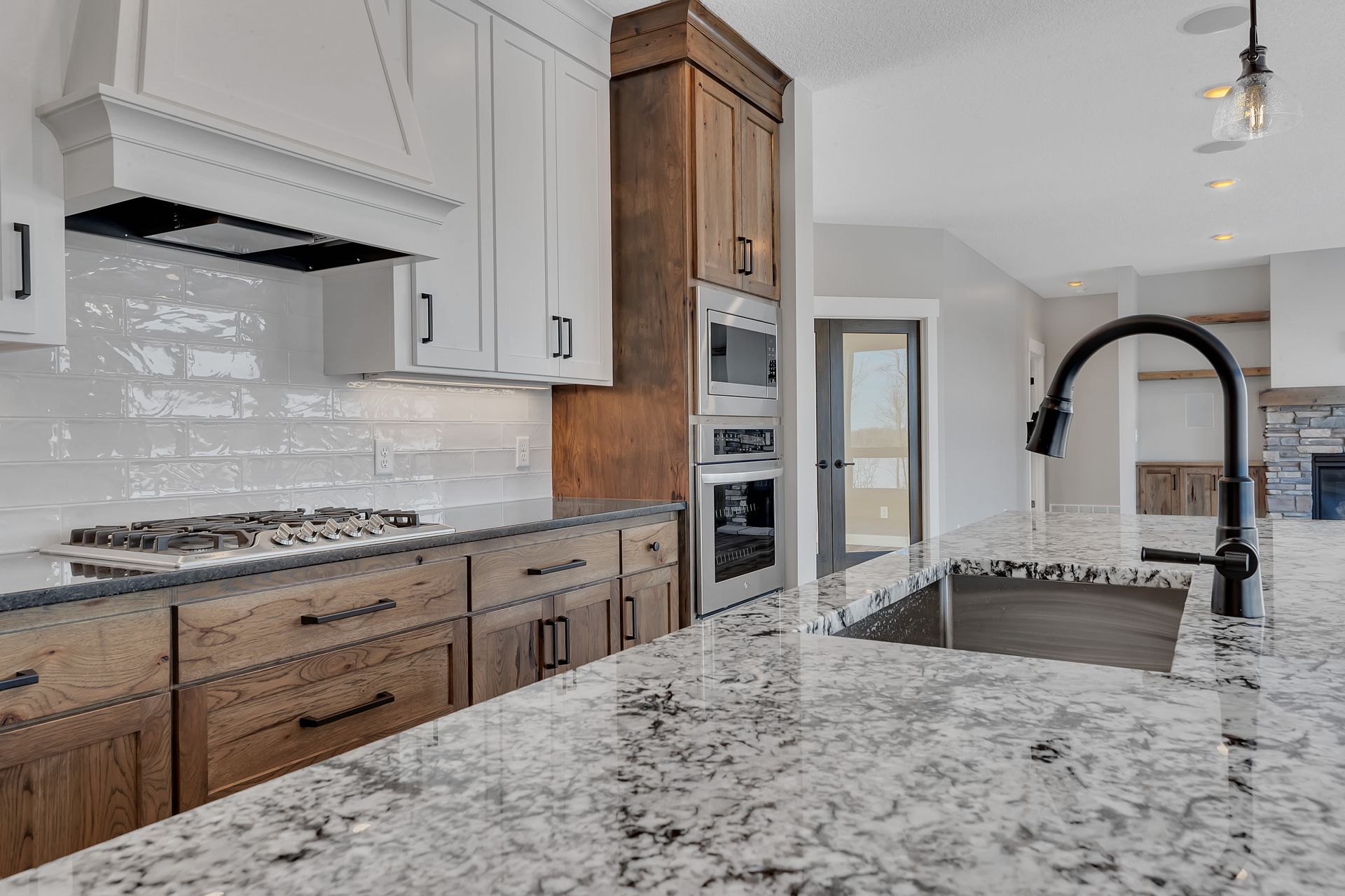A kitchen with granite counter tops , wooden cabinets , stainless steel appliances and a sink.