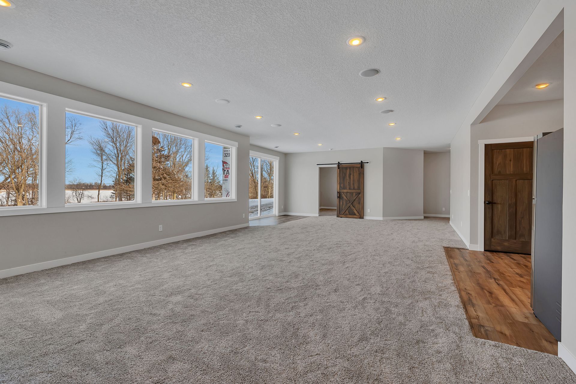 An empty basement with a lot of windows and carpet.