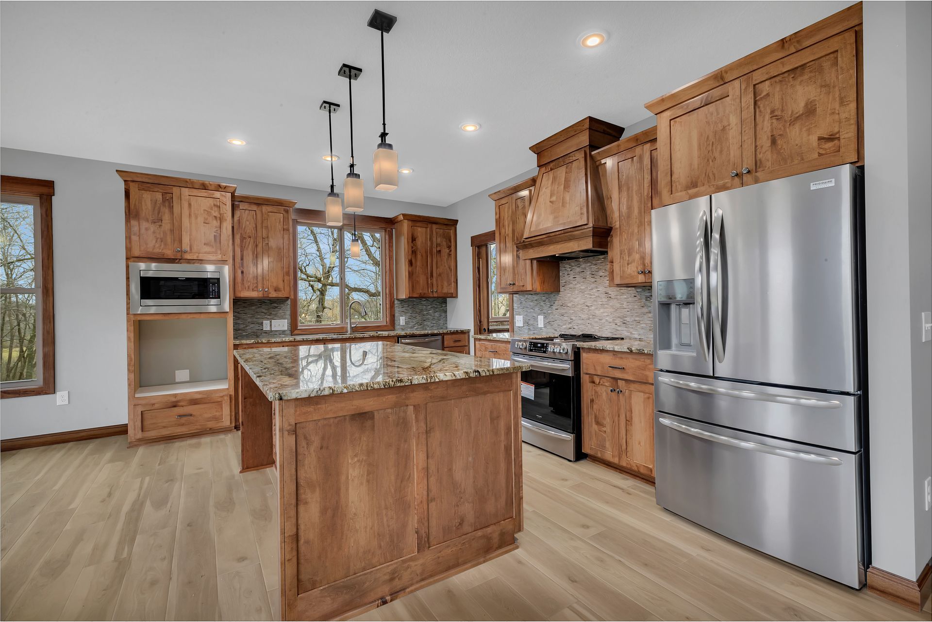 A kitchen with stainless steel appliances and wooden cabinets.
