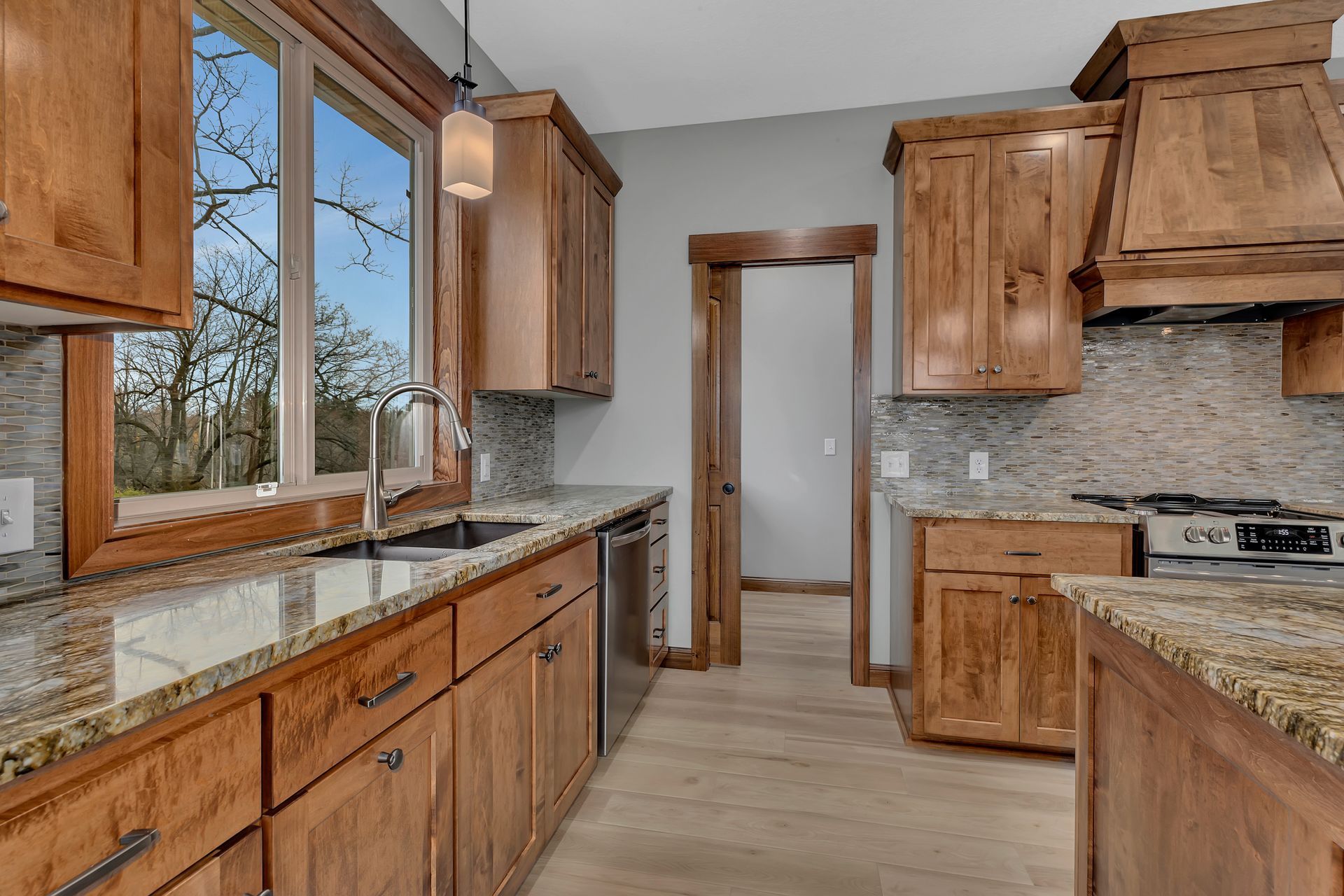 A kitchen with wooden cabinets and granite counter tops.