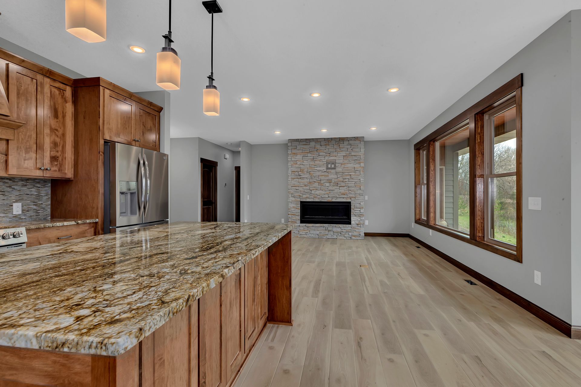 A kitchen with a granite counter top and a fireplace.