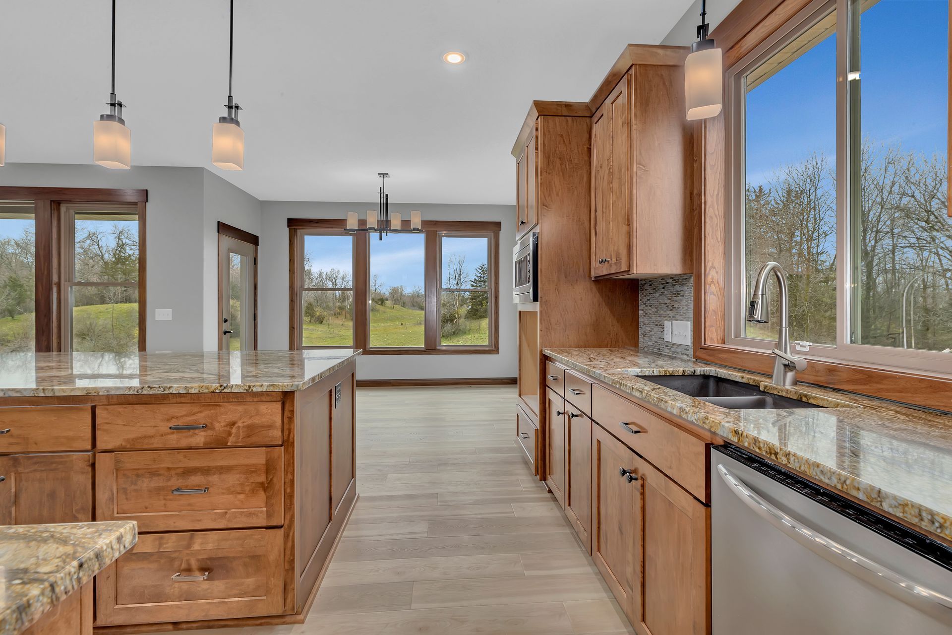 A kitchen with wooden cabinets , granite counter tops , and stainless steel appliances.