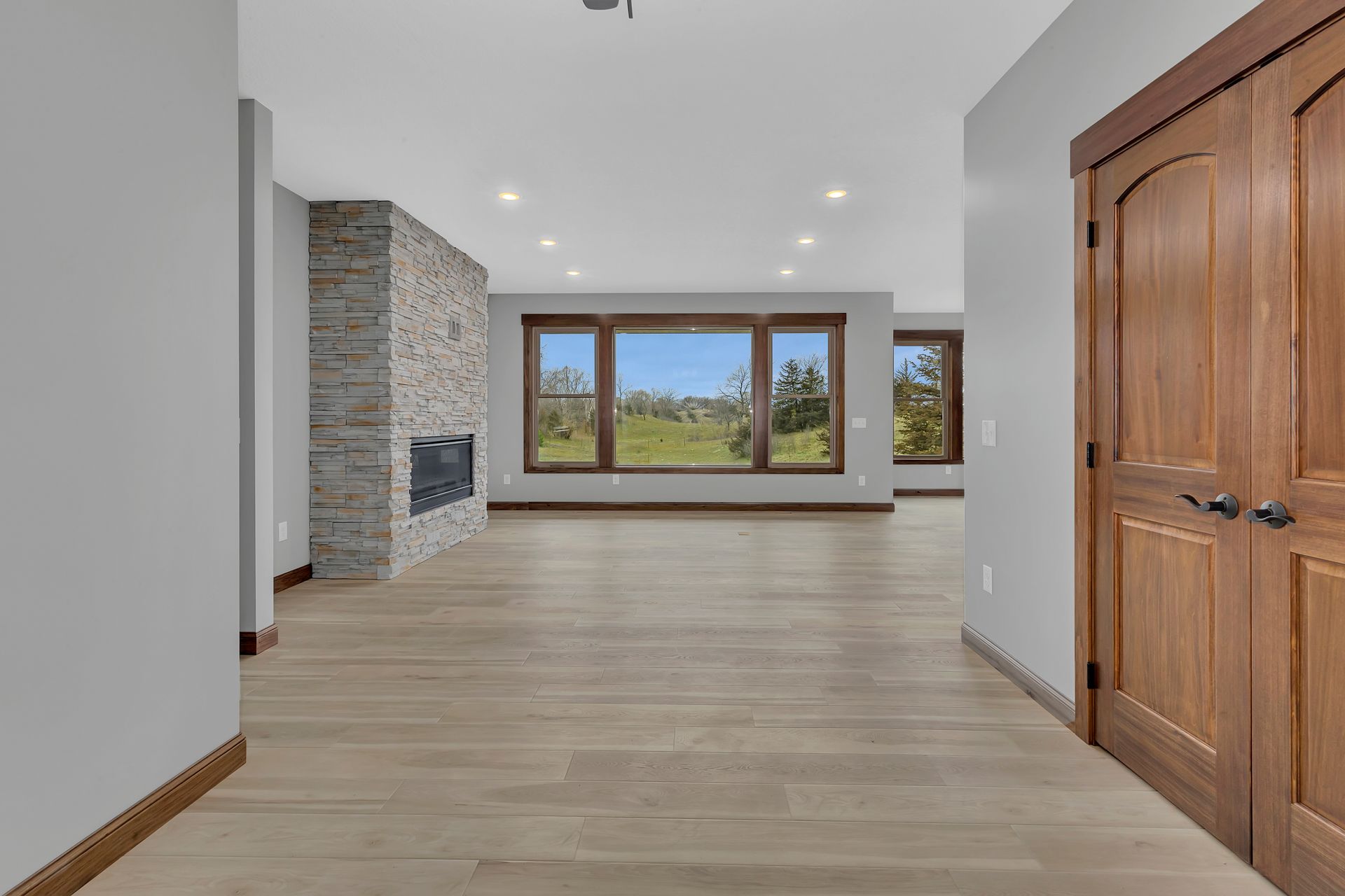 A large empty room with hardwood floors and a fireplace.