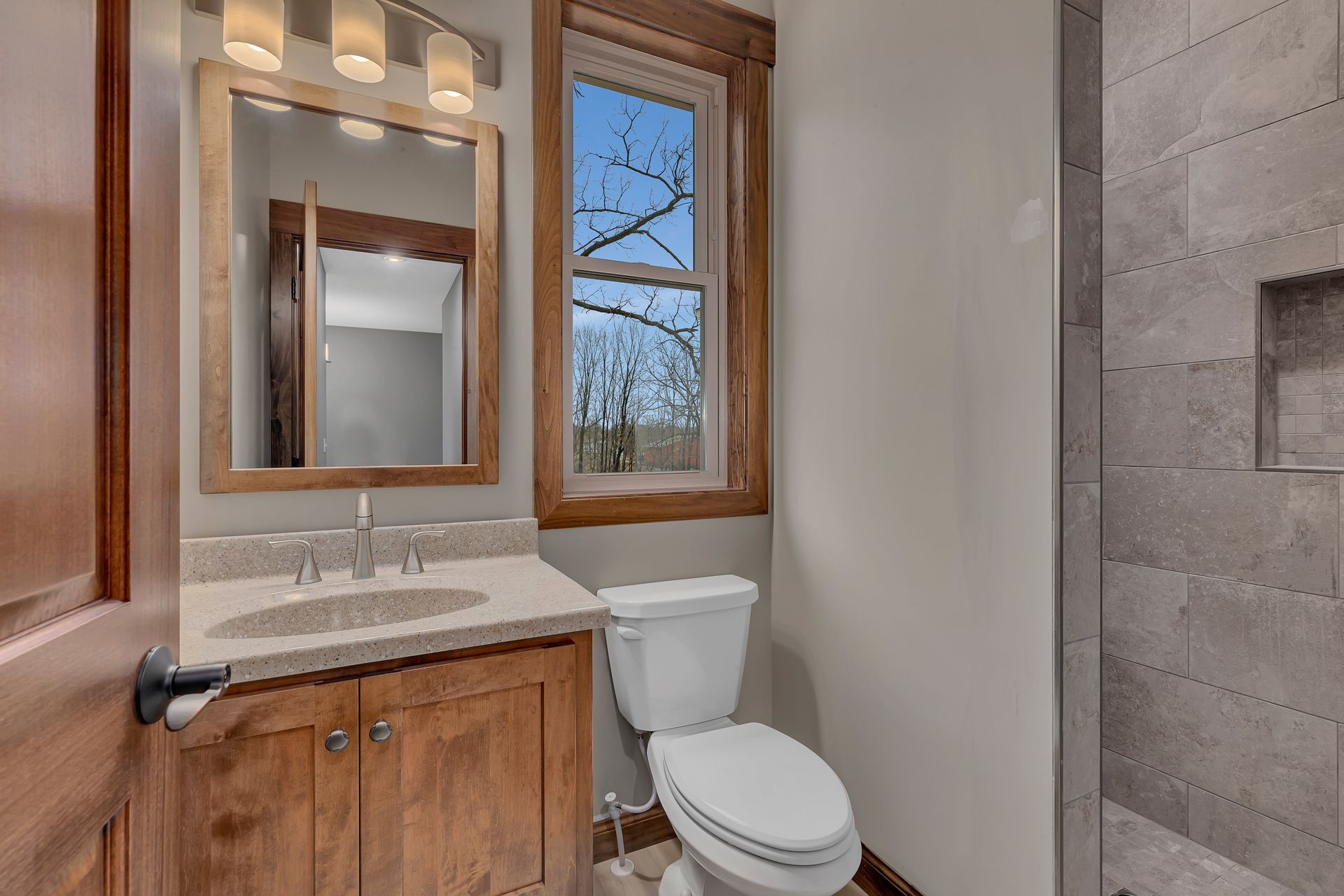 A bathroom with a toilet , sink and mirror.