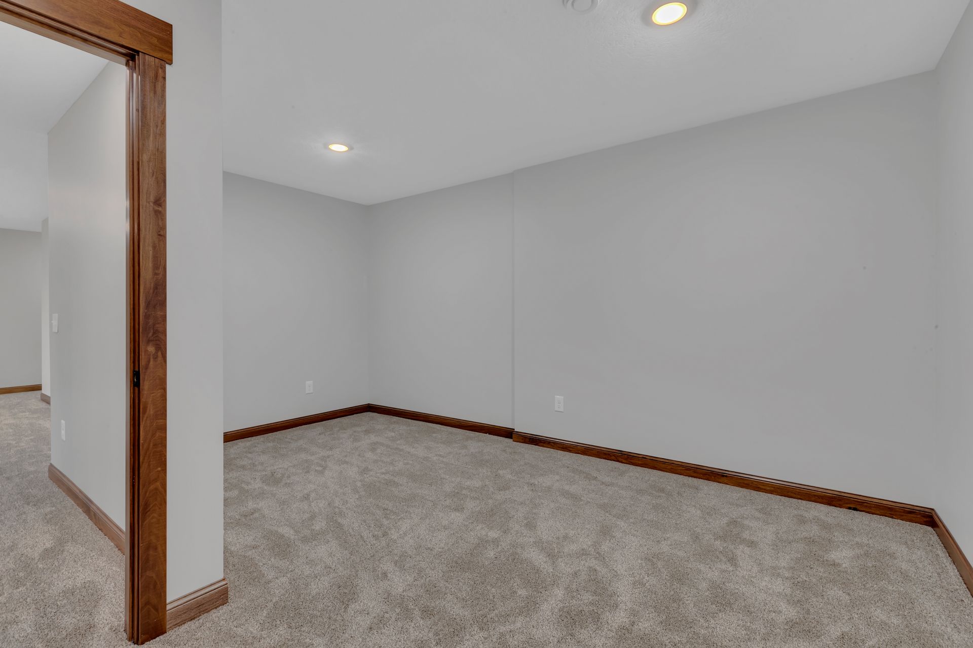 An empty room with a carpeted floor and white walls.