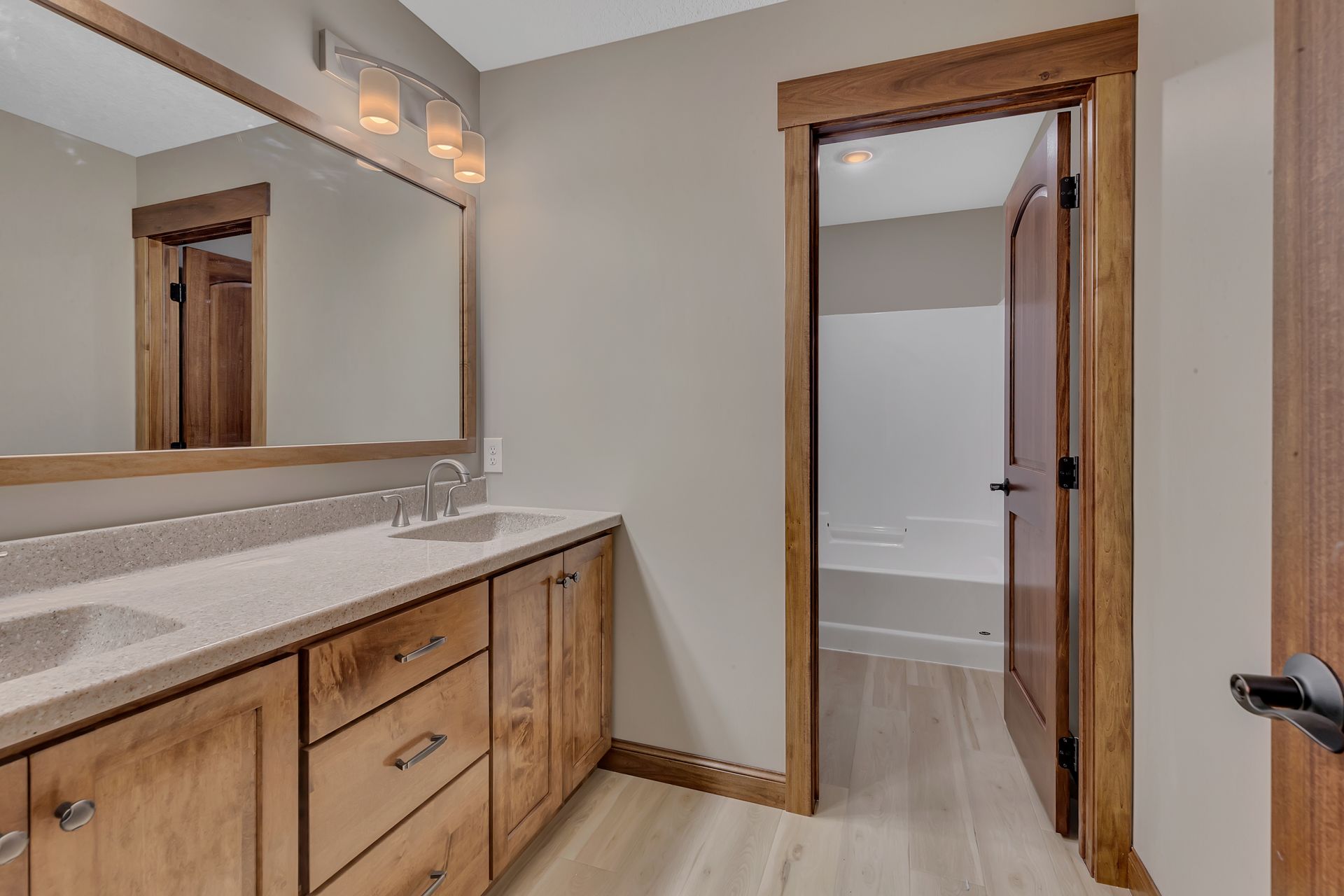 A bathroom with two sinks , a mirror and a tub.
