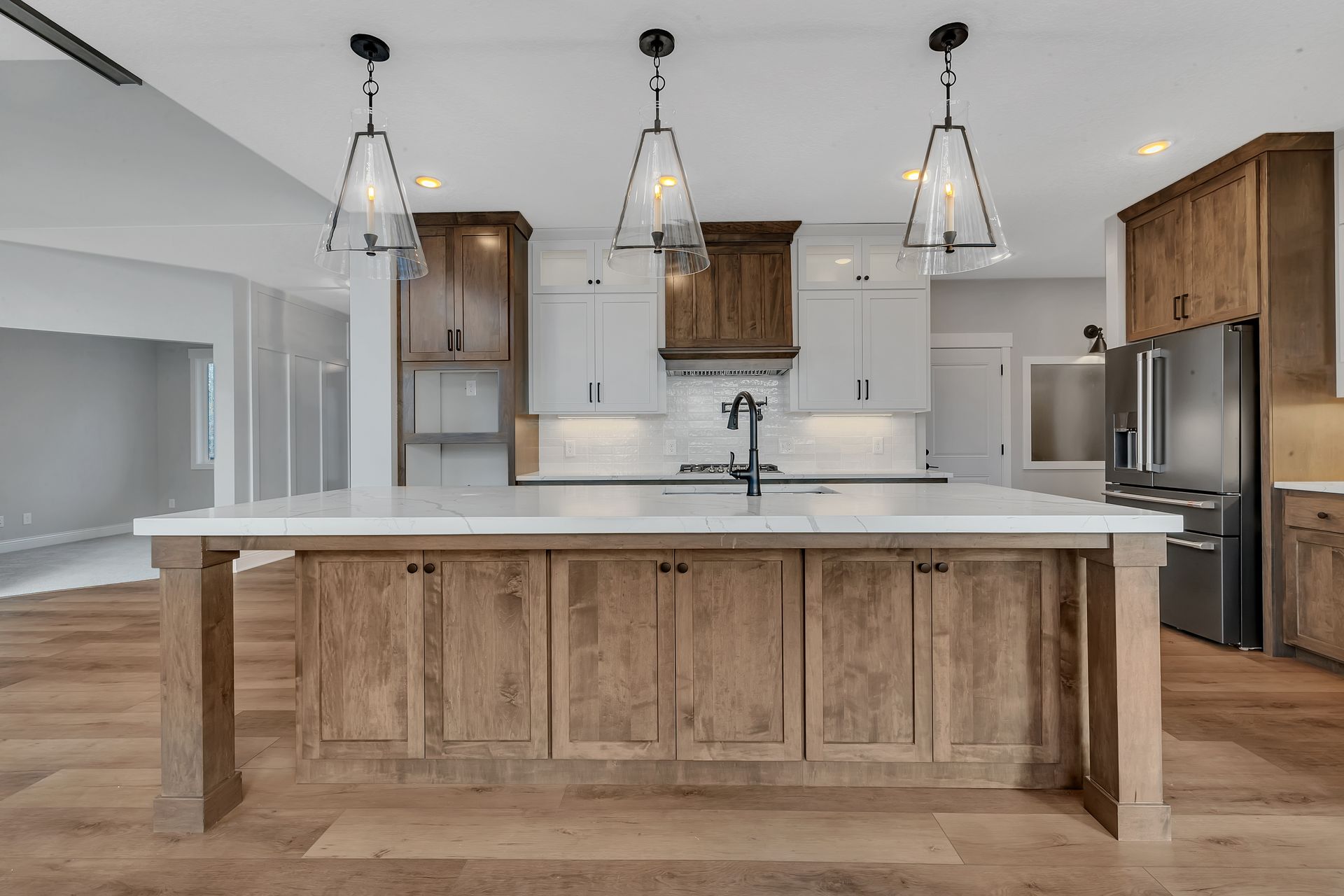 A kitchen with wooden cabinets and a large island in the middle.