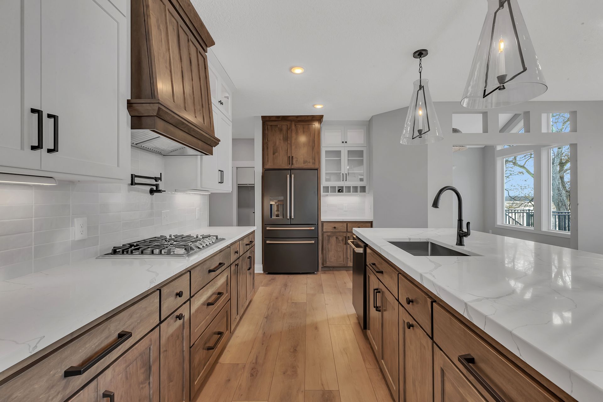 A kitchen with wooden cabinets , white counter tops , a refrigerator and a sink.