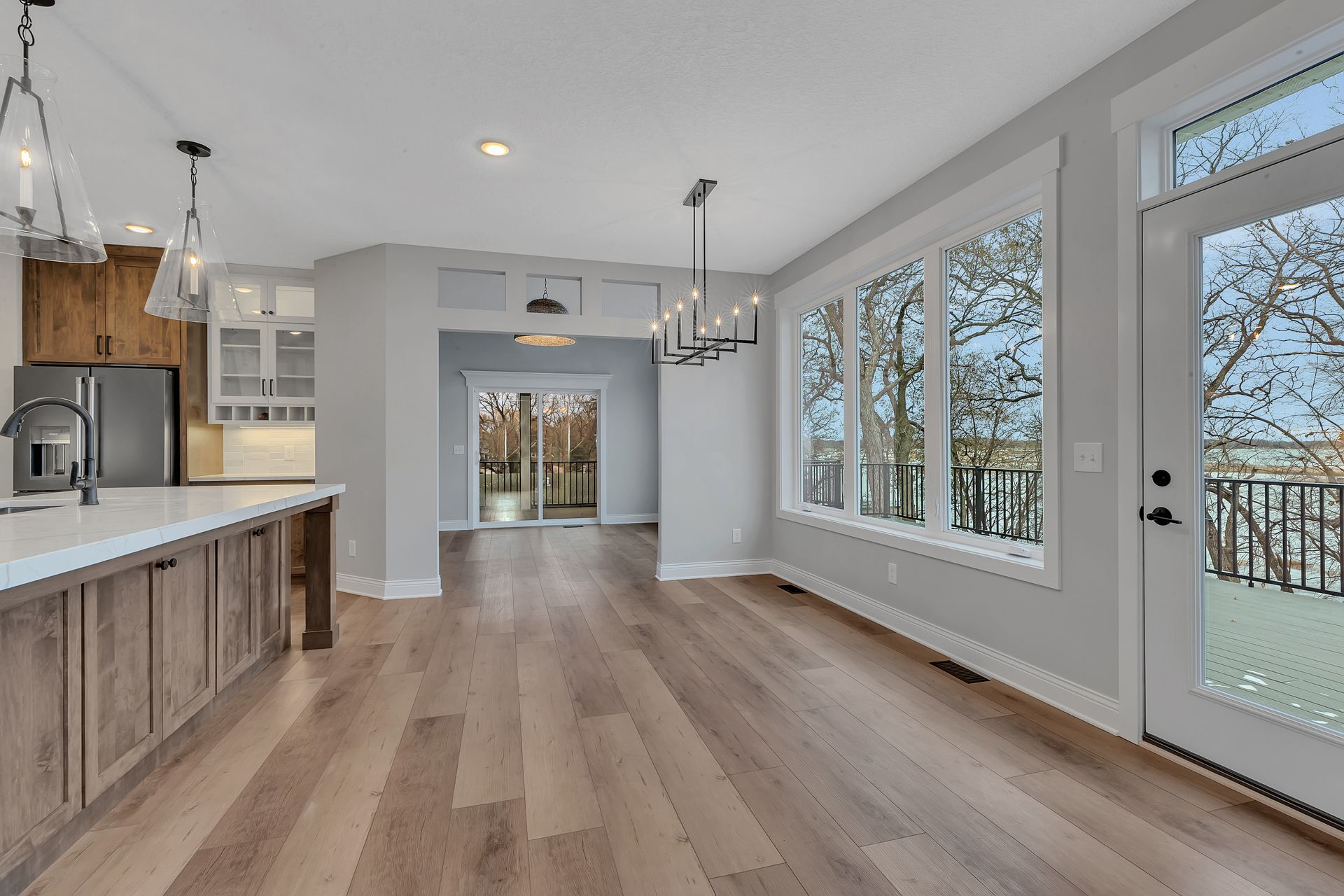 An empty kitchen with hardwood floors and lots of windows.