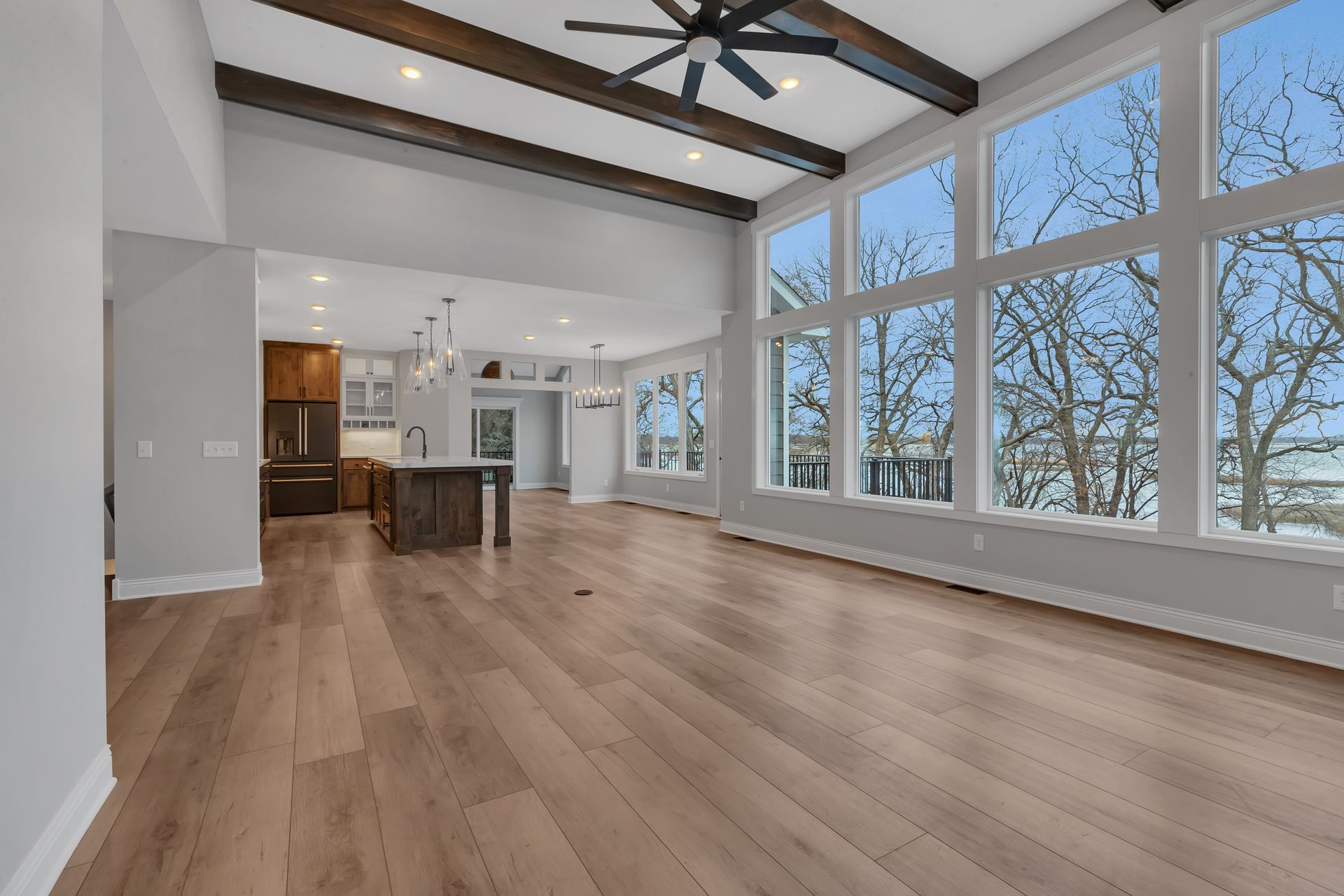 A large empty room with a lot of windows and a ceiling fan.