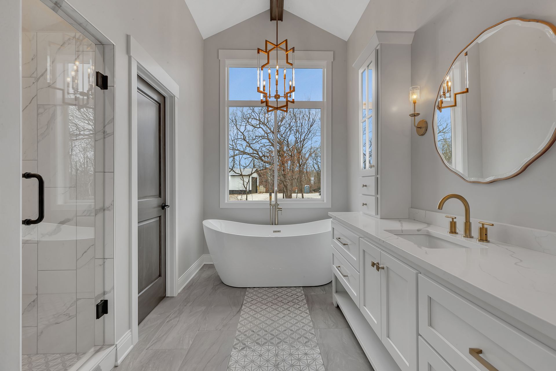 A bathroom with a tub , sink , mirror and shower.