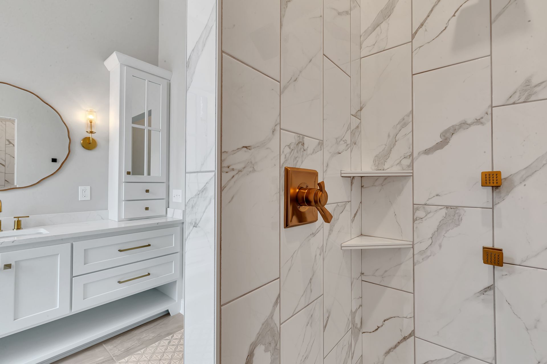 A bathroom with marble tiles and a walk in shower.