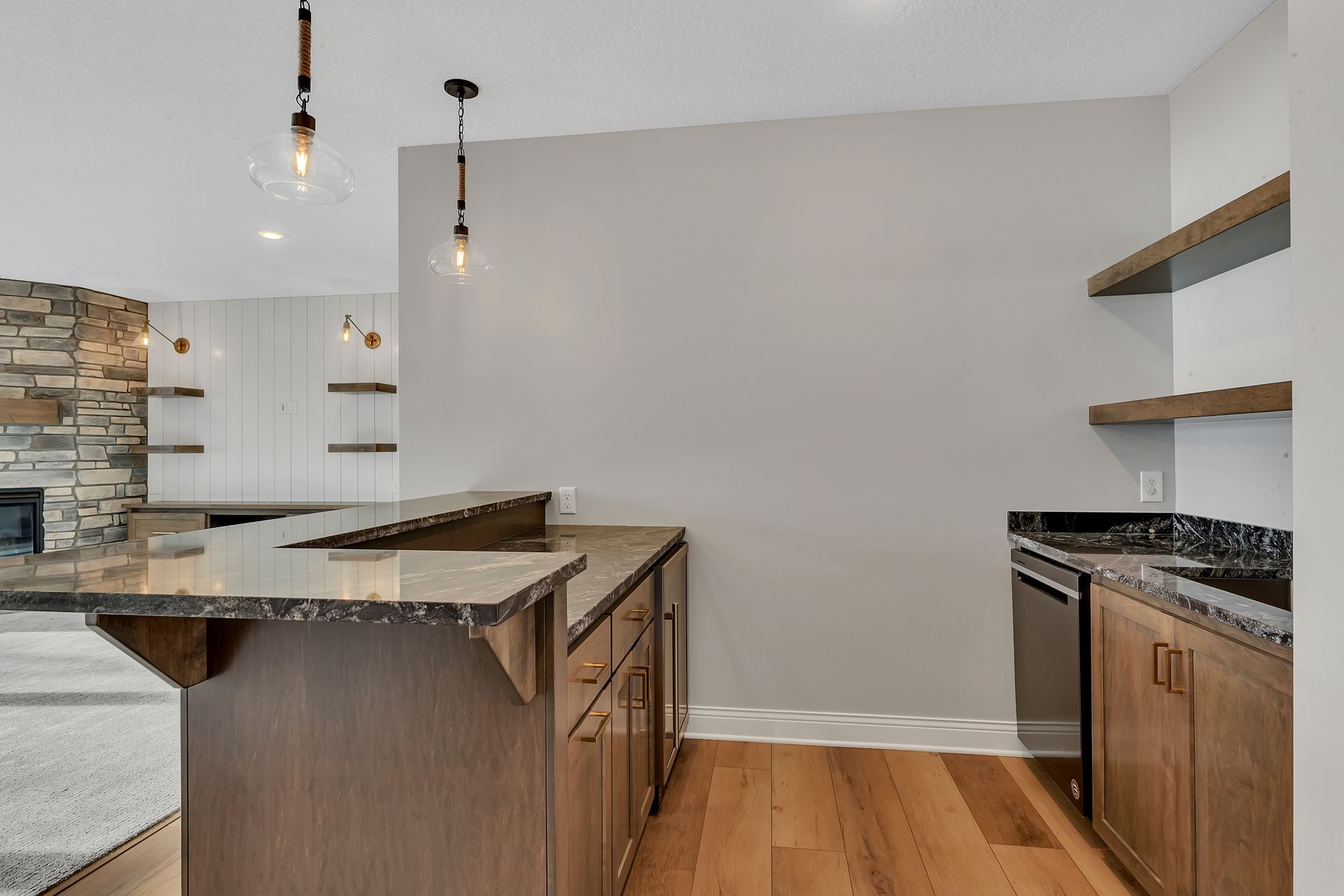 A kitchen with a large island , granite counter tops , and hardwood floors.