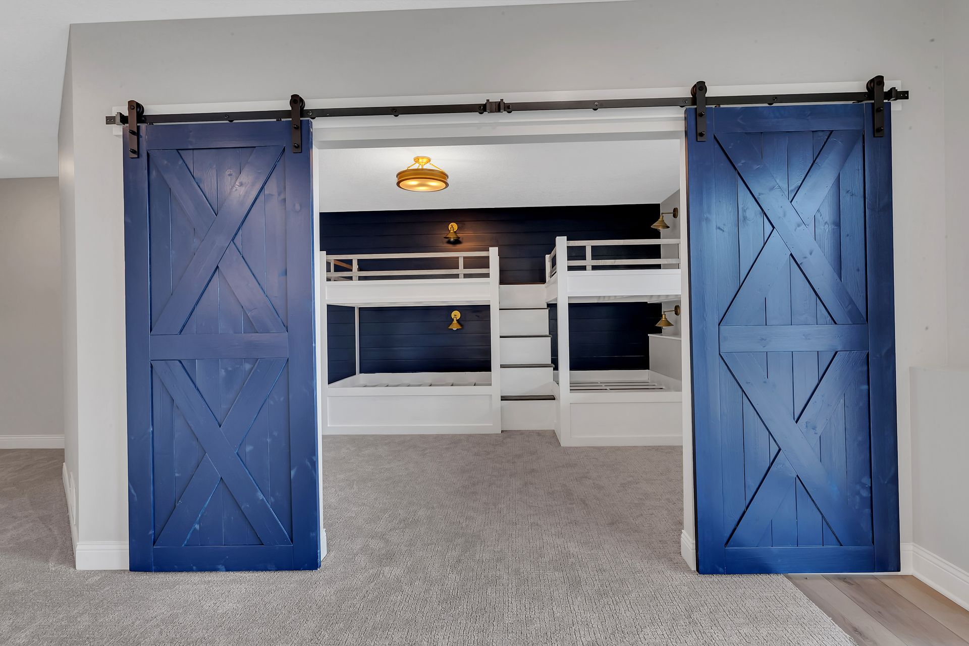A bedroom with bunk beds and blue barn doors.