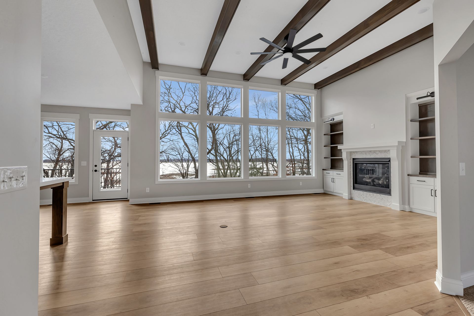 An empty living room with hardwood floors and a fireplace.
