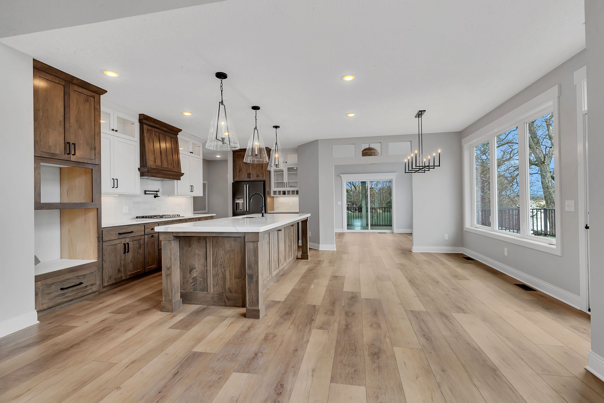 A kitchen with hardwood floors and a large island in the middle of the room.