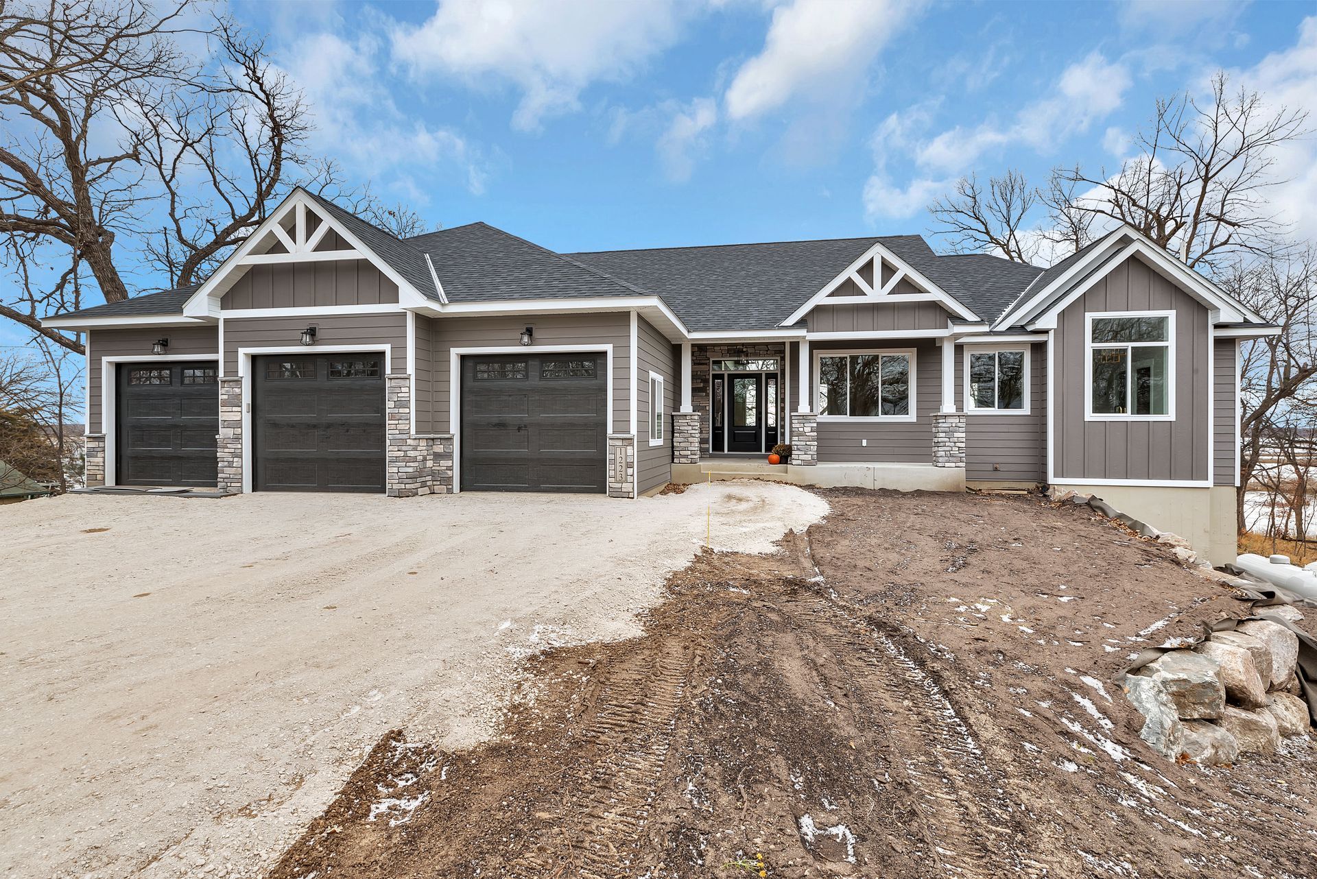 A large house is sitting on top of a dirt hill.