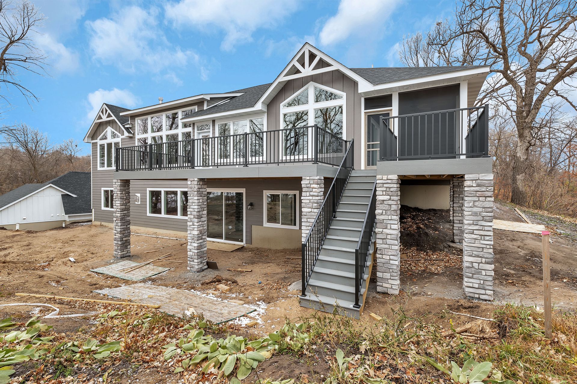 A large house with a large deck and stairs.