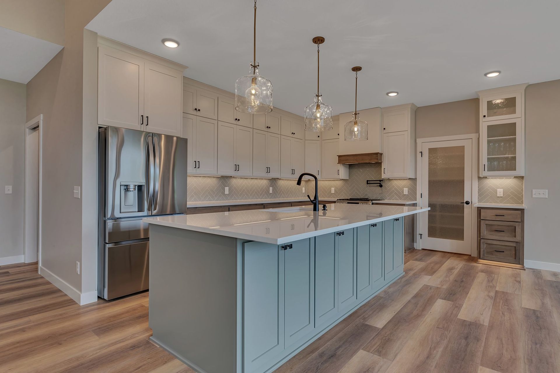 A kitchen with a large island and stainless steel appliances.