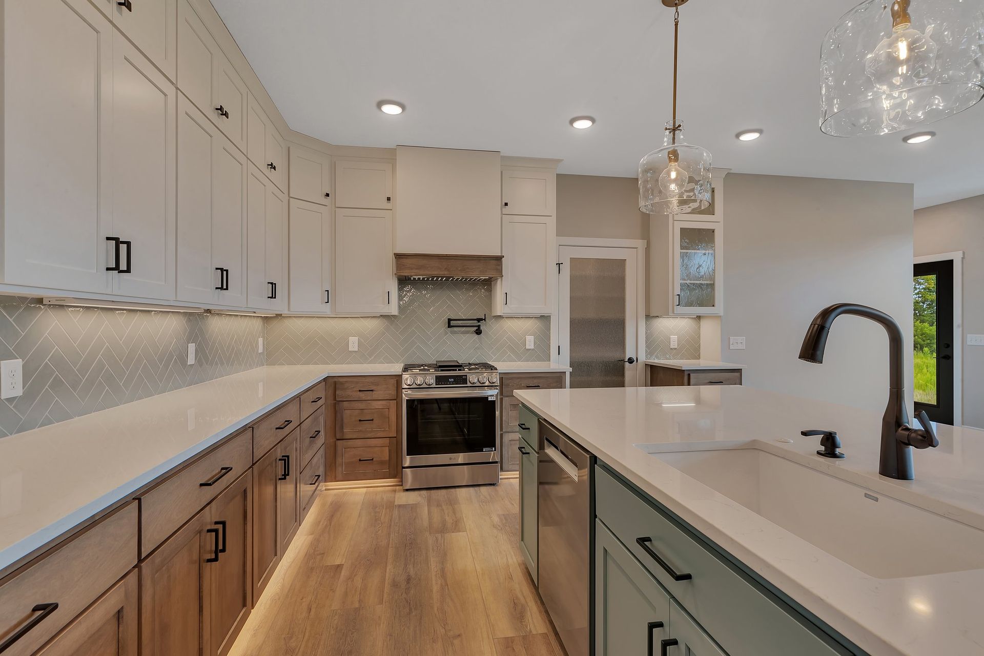 A kitchen with white cabinets , stainless steel appliances , a sink , and a stove.