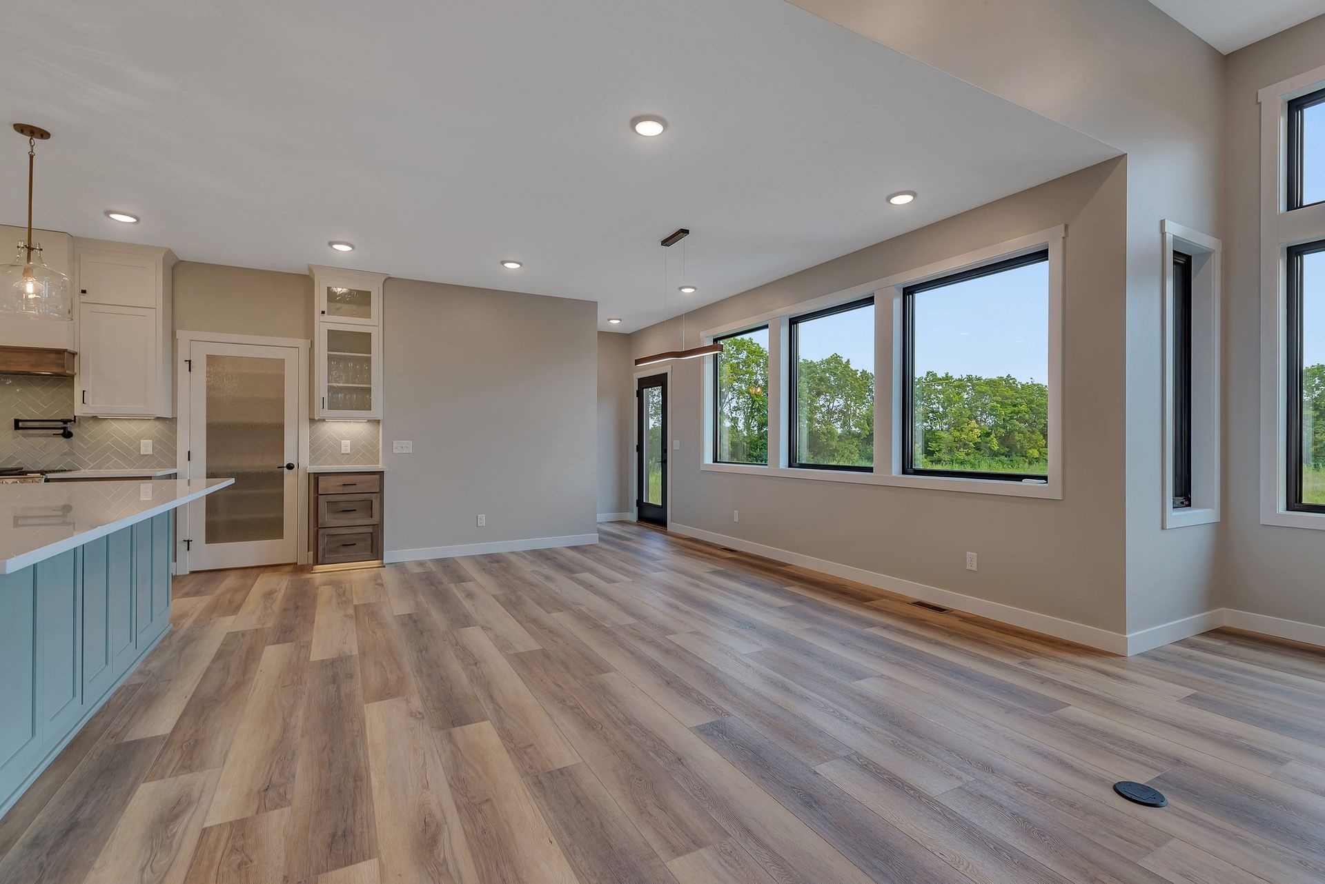 A large empty room with hardwood floors and lots of windows.