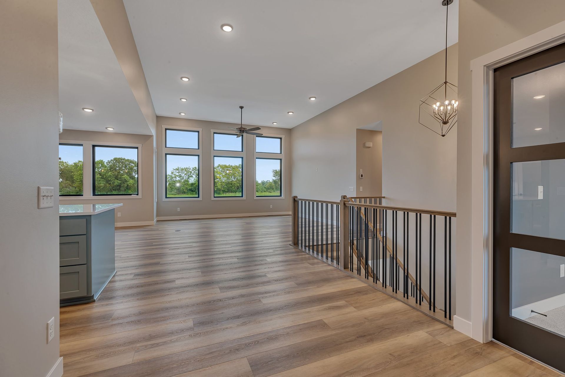 A large empty room with hardwood floors and a ceiling fan.