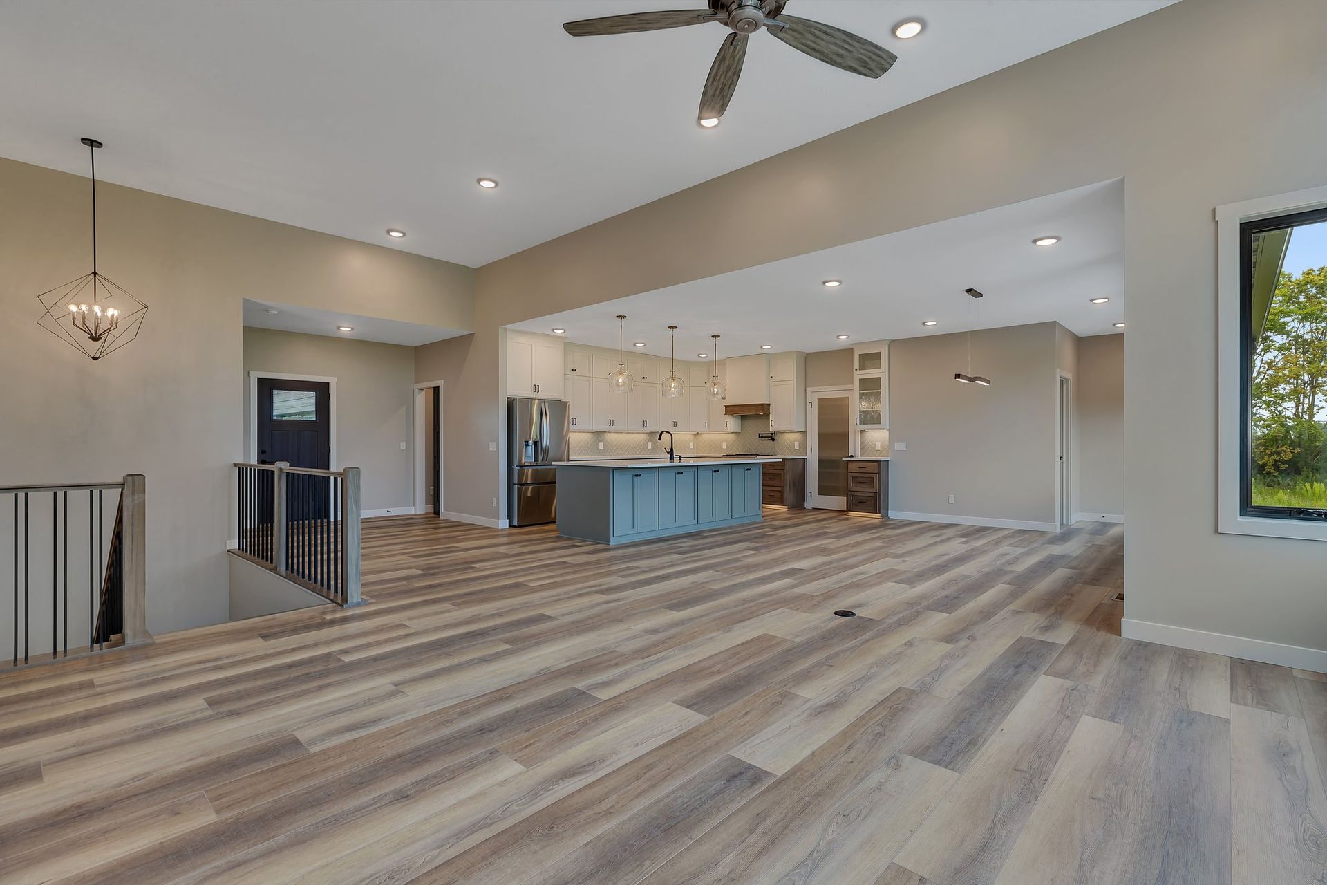 A living room with hardwood floors and a ceiling fan in a house.