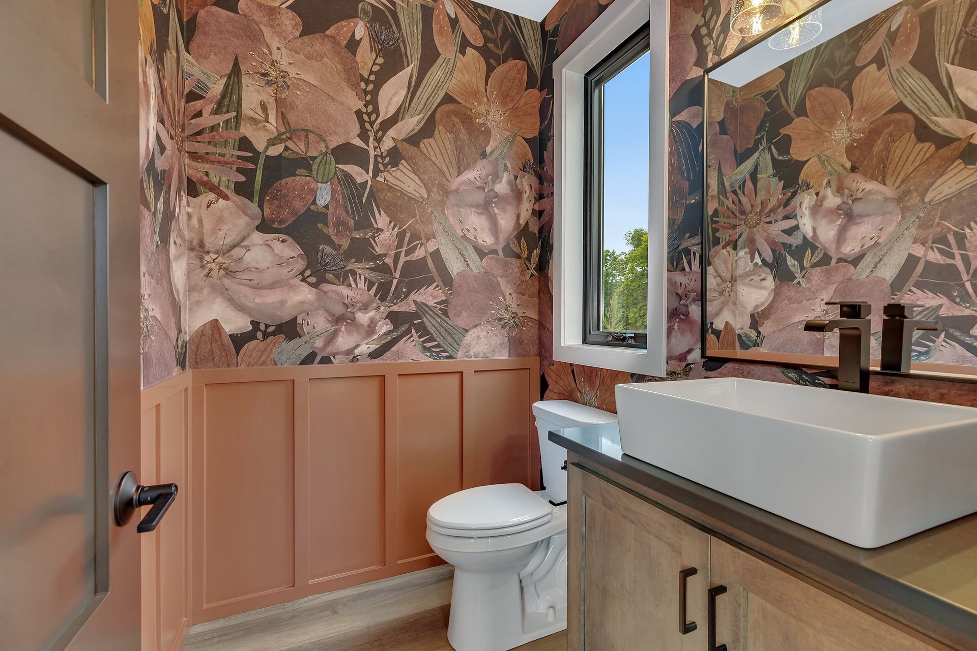 A bathroom with a toilet , sink and mirror.