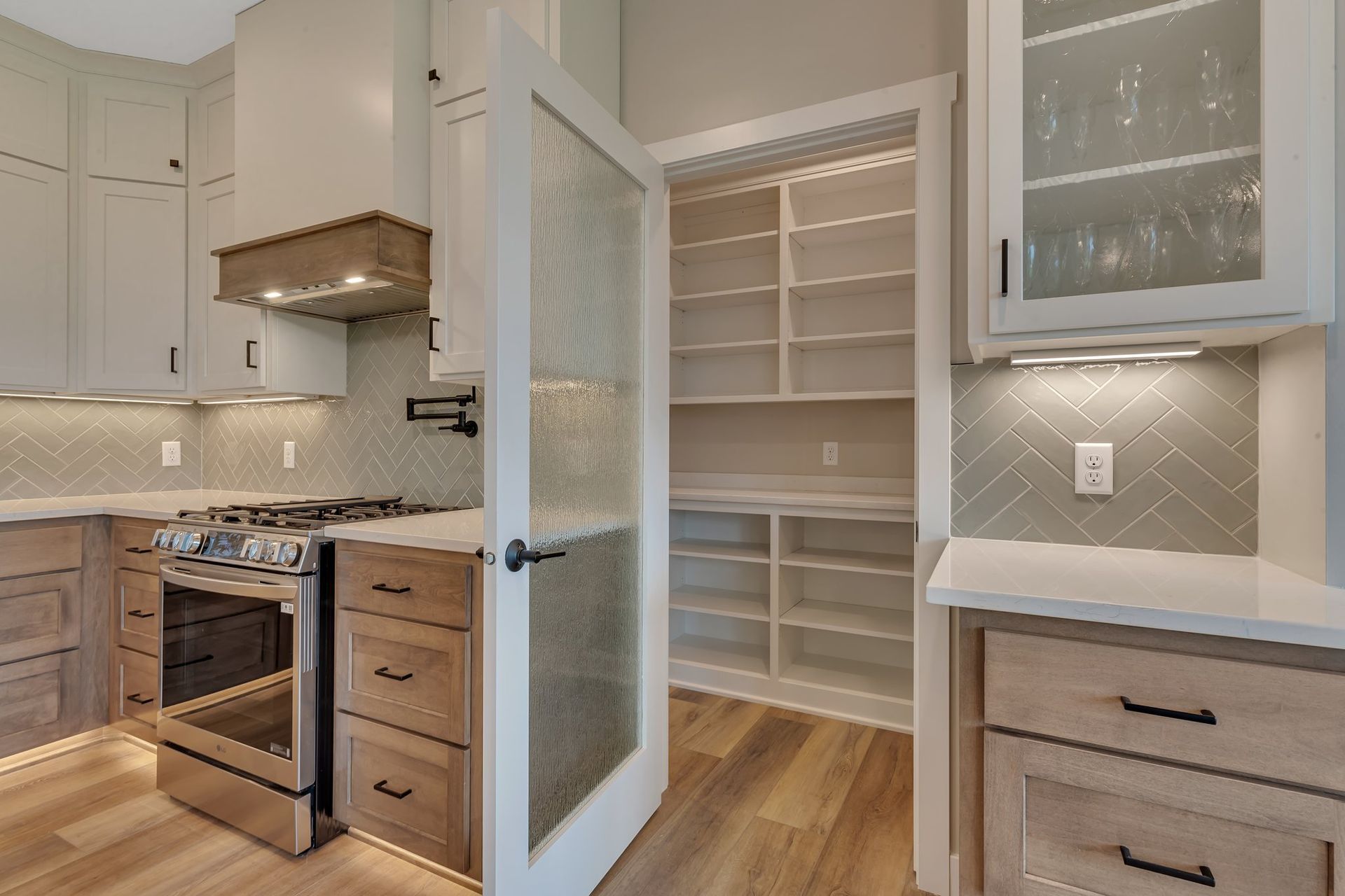 A kitchen with stainless steel appliances , wooden cabinets , and a pantry.