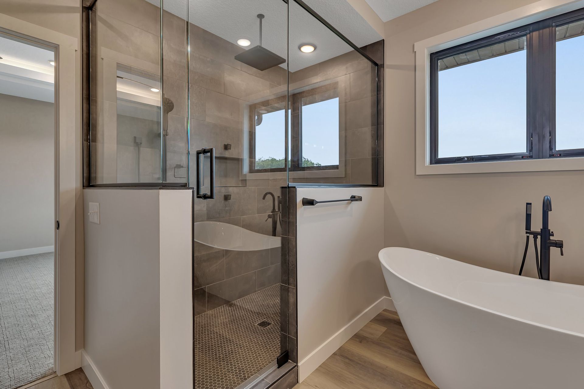 A bathroom with a tub , shower , and window.