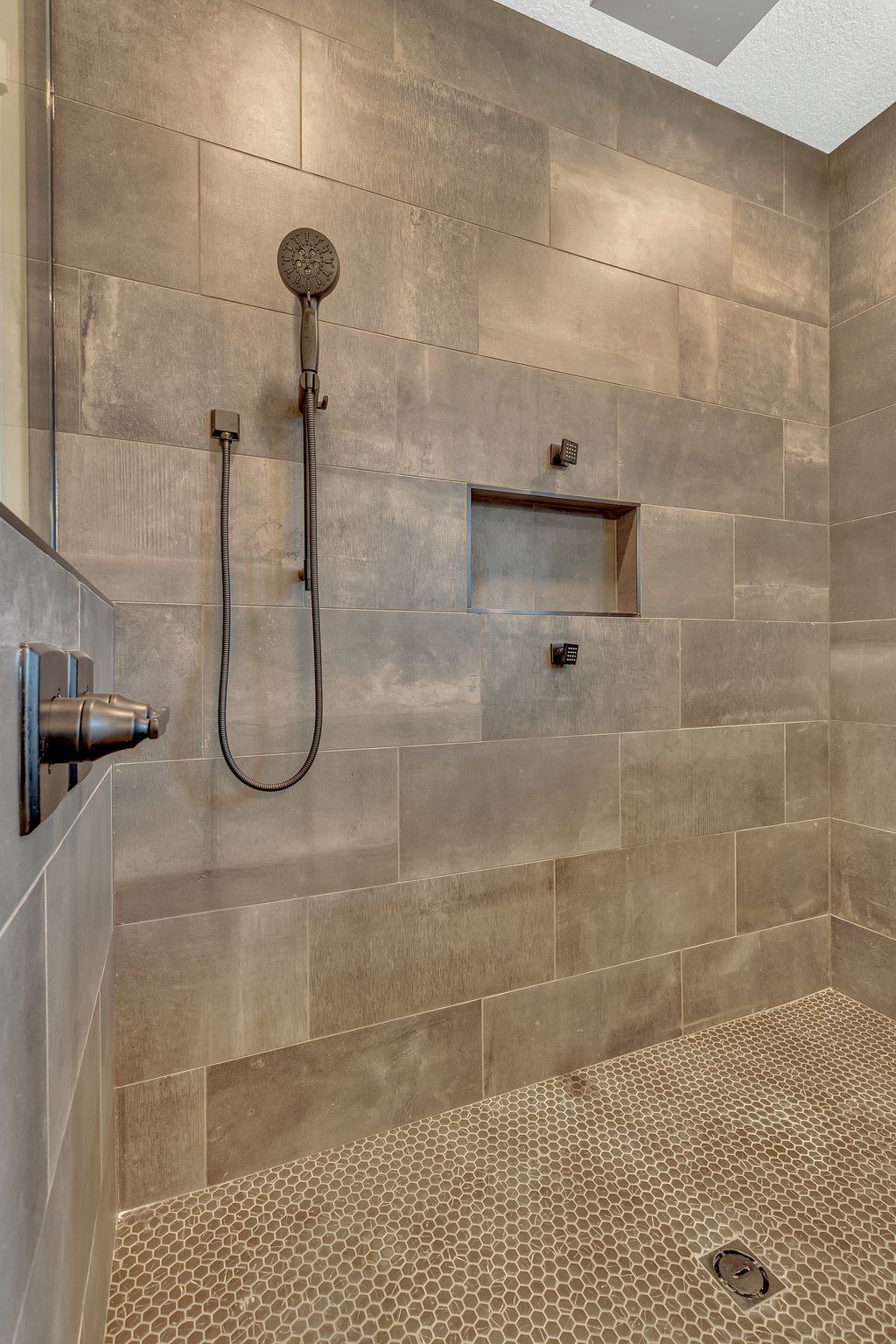 A bathroom with a walk in shower and a shower head.