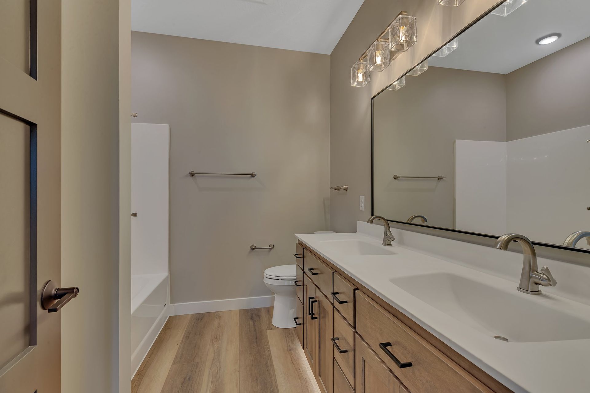 A bathroom with two sinks , a toilet , and a large mirror.